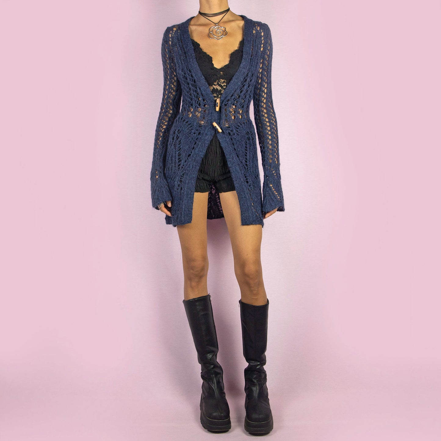 The Y2K Blue Long Crochet Cardigan is a vintage 2000s cardigan featuring a deep V-neckline and long, flared sleeves. Made from a wool blend, this longline cardigan is lightweight yet cozy, with wooden toggle button closures and a stretchy design. Perfect for layering over outfits in cooler weather.