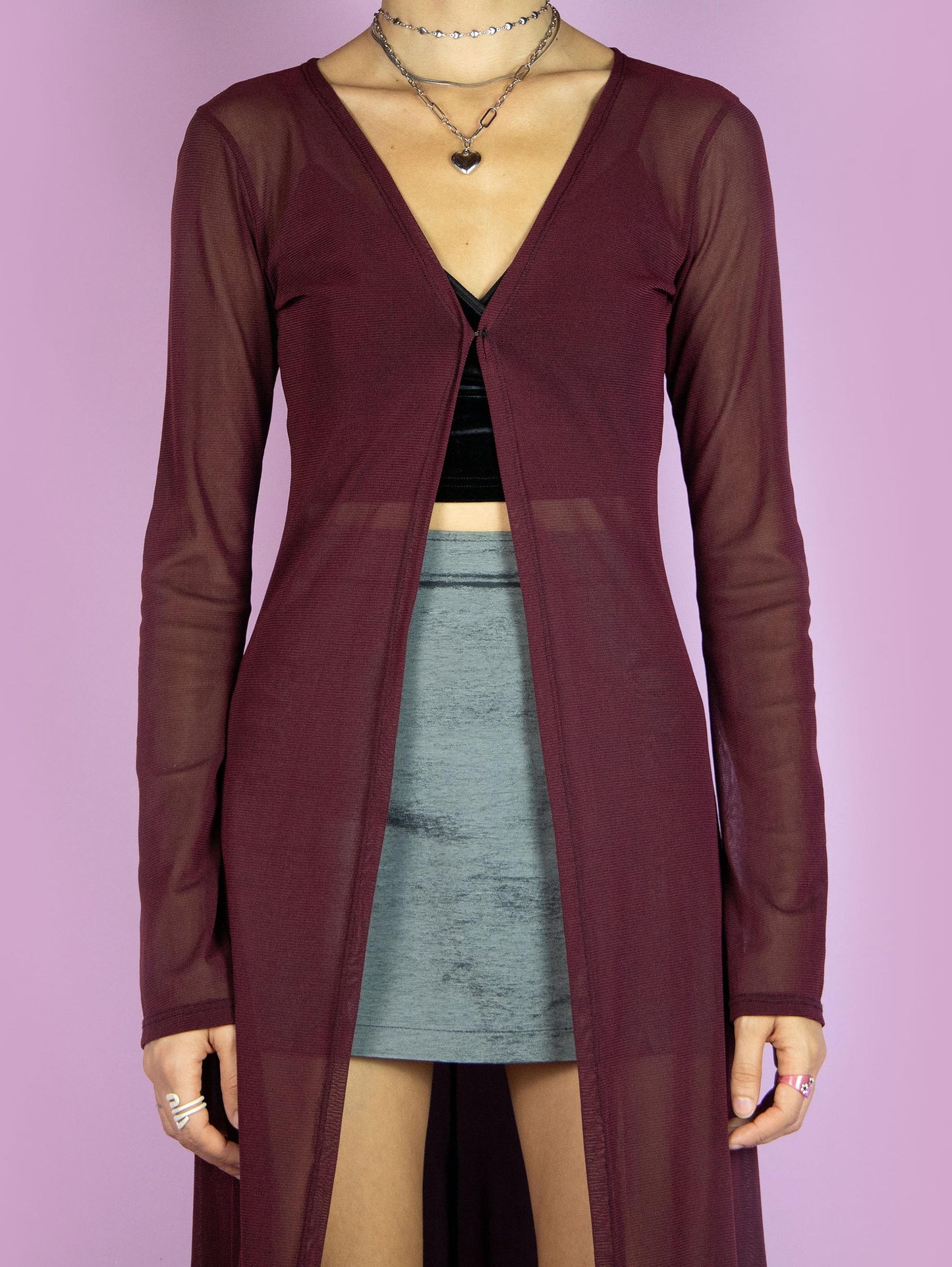 The Y2K Maroon Mesh Duster Jacket is a vintage 2000s cyber festival rave party style burgundy semi-sheer maxi long coat with bell sleeves and a front hook closure.