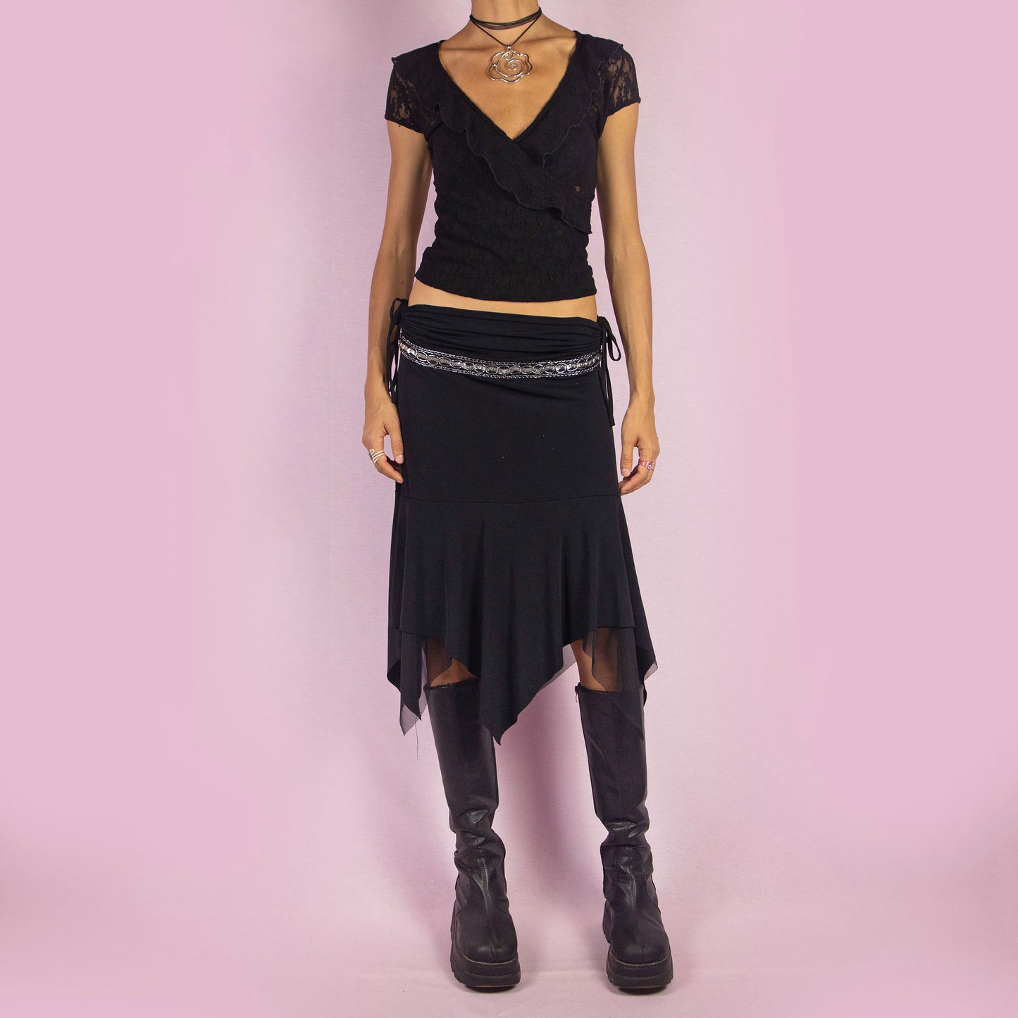 The Y2K Black Layered Asymmetric Skirt is a vintage 2000s piece featuring an avant-garde design. It has intricate bead detailing on the waist and adjustable ruched side ties. The skirt includes mesh sheer layers and a handkerchief-style asymmetric hemline, making it perfect for a bold night out look.