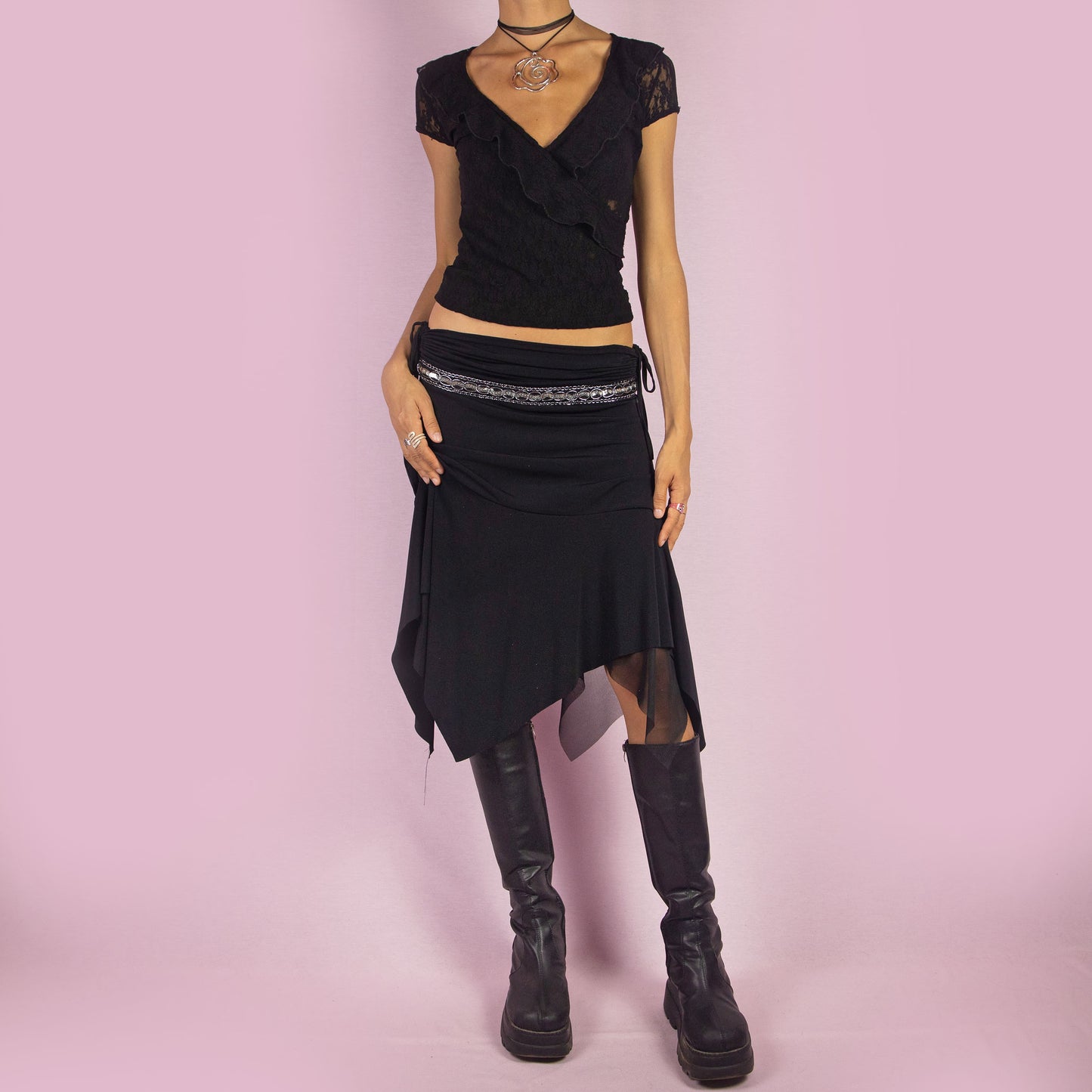 The Y2K Black Layered Asymmetric Skirt is a vintage 2000s piece featuring an avant-garde design. It has intricate bead detailing on the waist and adjustable ruched side ties. The skirt includes mesh sheer layers and a handkerchief-style asymmetric hemline, making it perfect for a bold night out look.