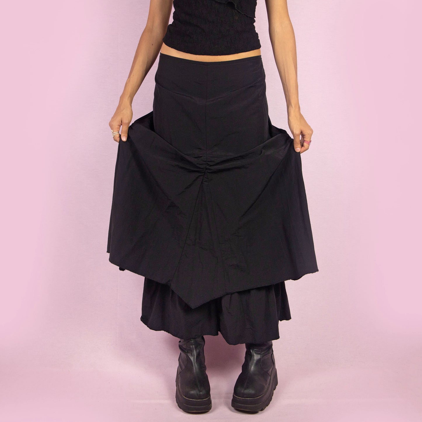 The Y2K Black Layered Midi Skirt is a vintage 2000s piece that features a unique, layered design with ruched details along the front. It includes a back zipper closure and a high-waisted fit. Perfect for both casual and night-out outfits.