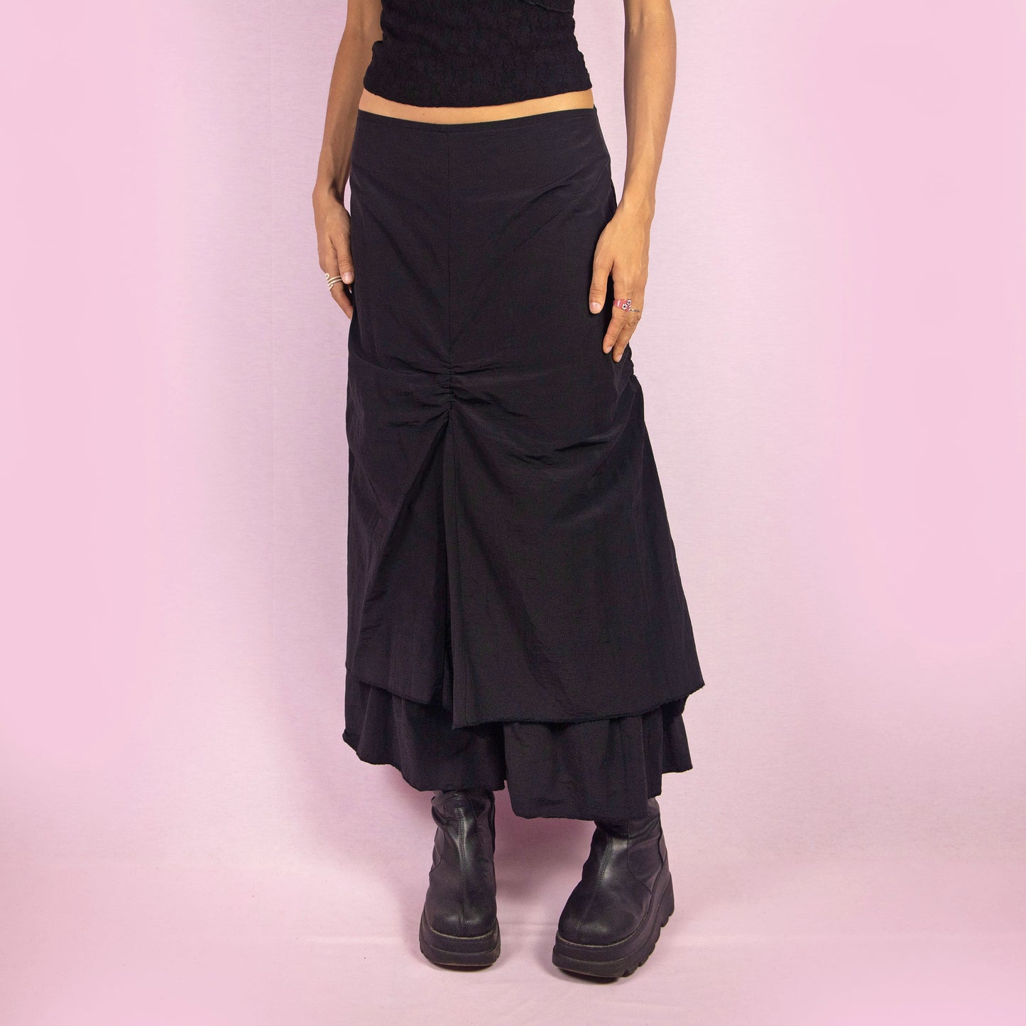 The Y2K Black Layered Midi Skirt is a vintage 2000s piece that features a unique, layered design with ruched details along the front. It includes a back zipper closure and a high-waisted fit. Perfect for both casual and night-out outfits.