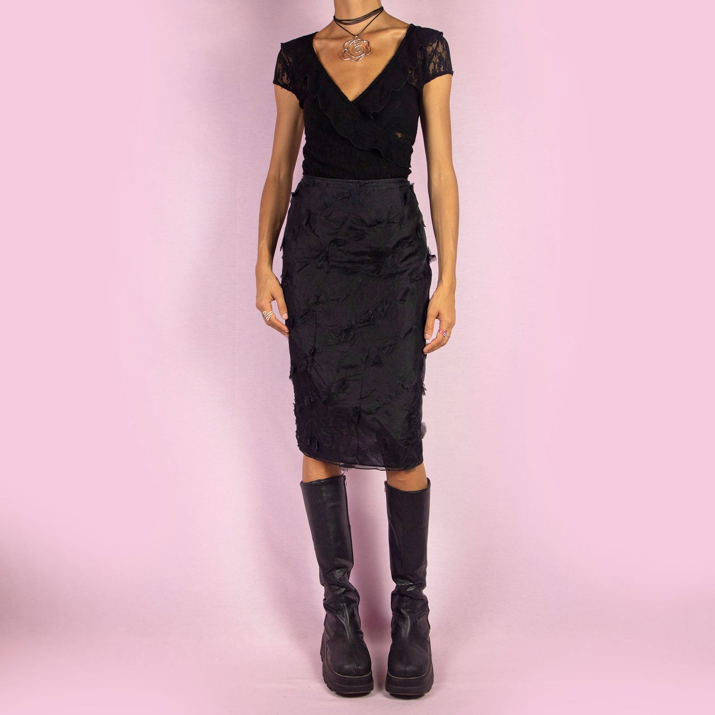 The Y2K Black Applique Midi Skirt is a vintage 2000s piece featuring intricate appliqué details throughout. This elegant skirt has a side zipper closure and a flattering high-waisted fit. It is semi-sheer, making it perfect for special occasions.