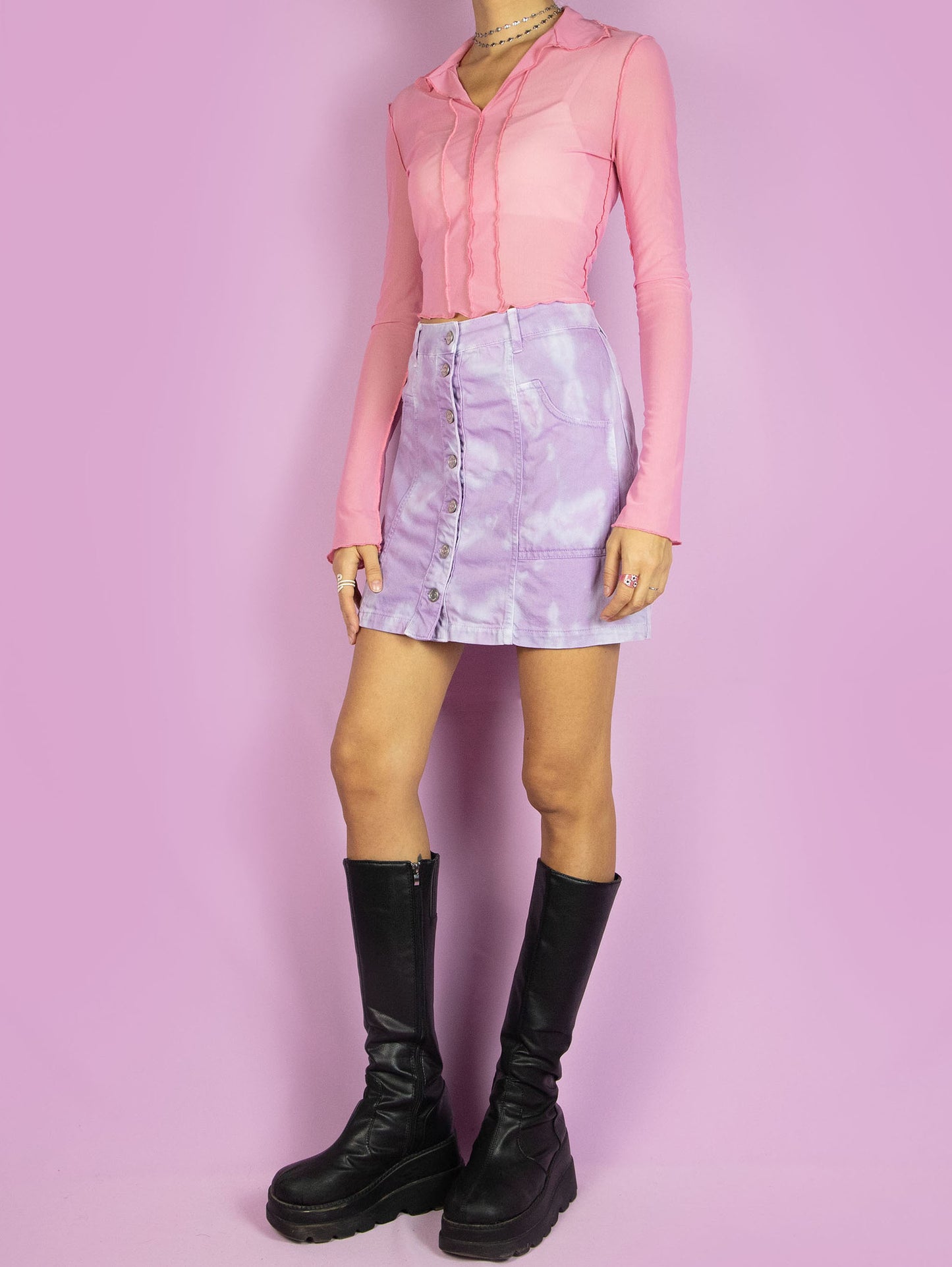 The Y2K Tie Dye Mini Skirt is a vintage 2000s summer festival style pastel purple lilac and blue bleached denim a-line skirt with pockets and buttons.