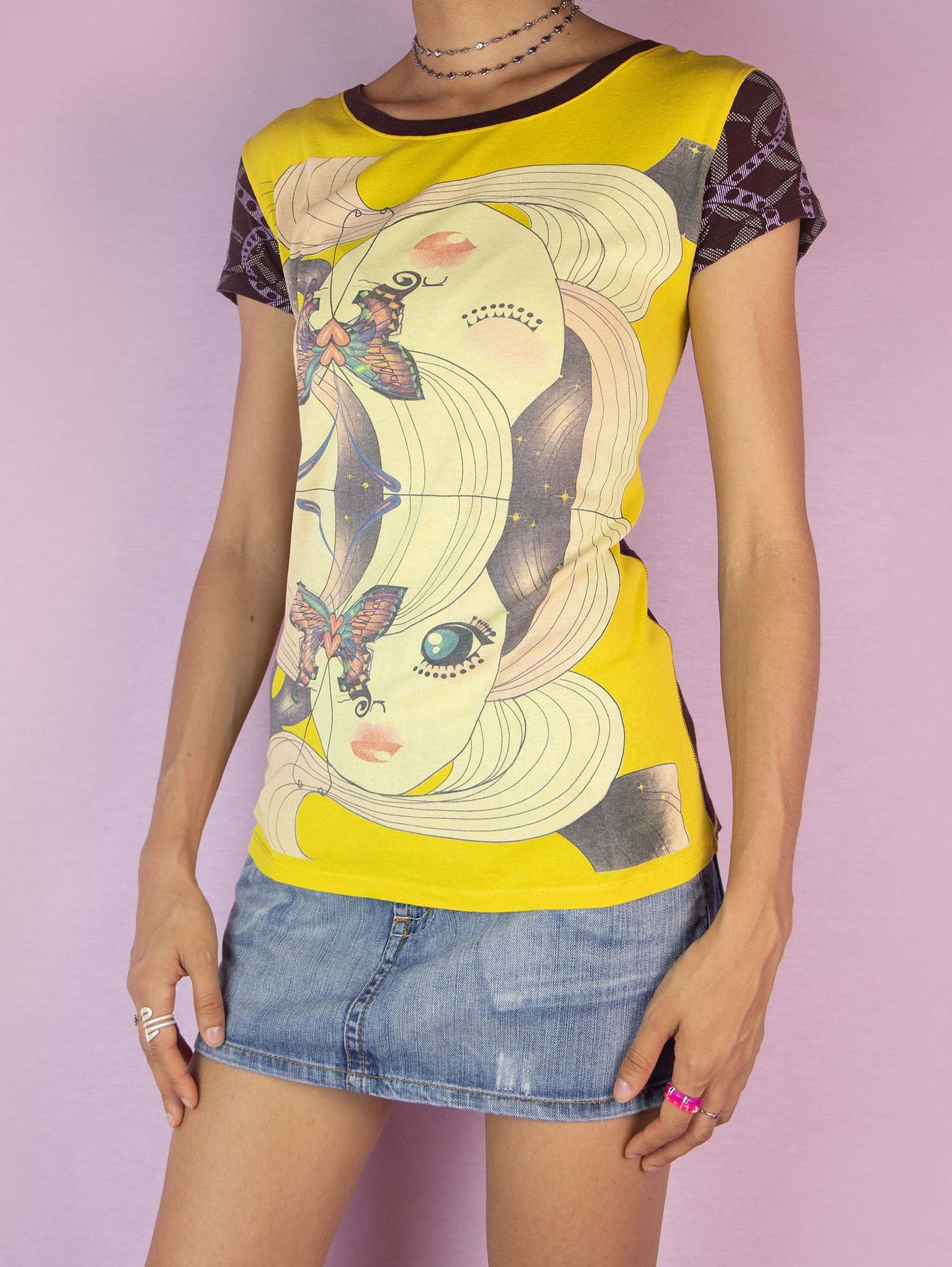 The Y2K Custo Barcelona Graphic Top is a vintage 2000s t-shirt featuring a vibrant multicolored graphic on the front and intricate print details on the short sleeves. The back showcases additional graphic elements. Perfect for a casual summer look.
