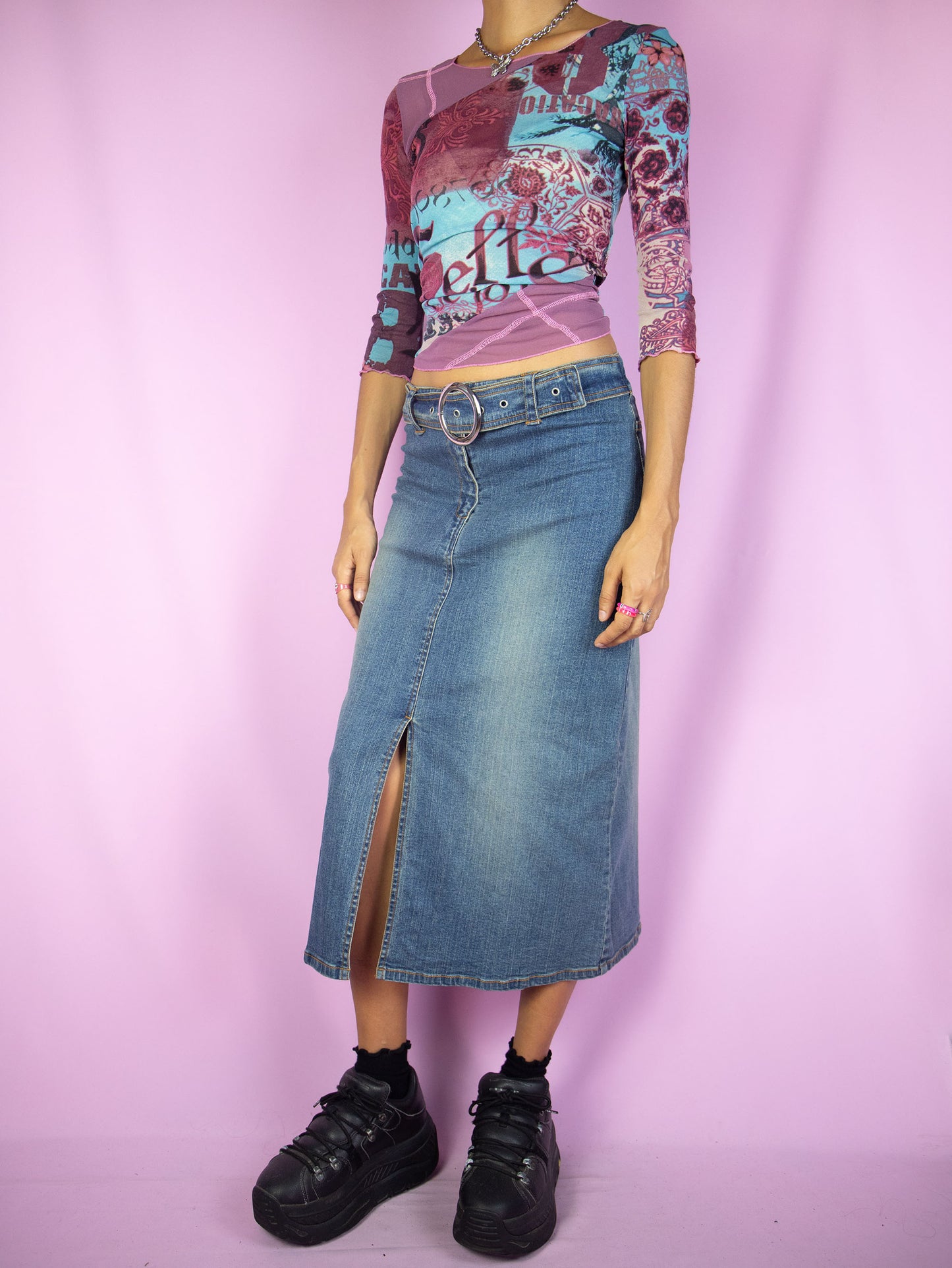 The Y2K Denim Midi Skirt is a vintage 2000s cyber grunge inspired stretchy jean maxi skirt with a front slit, belt buckle and zipper closure.