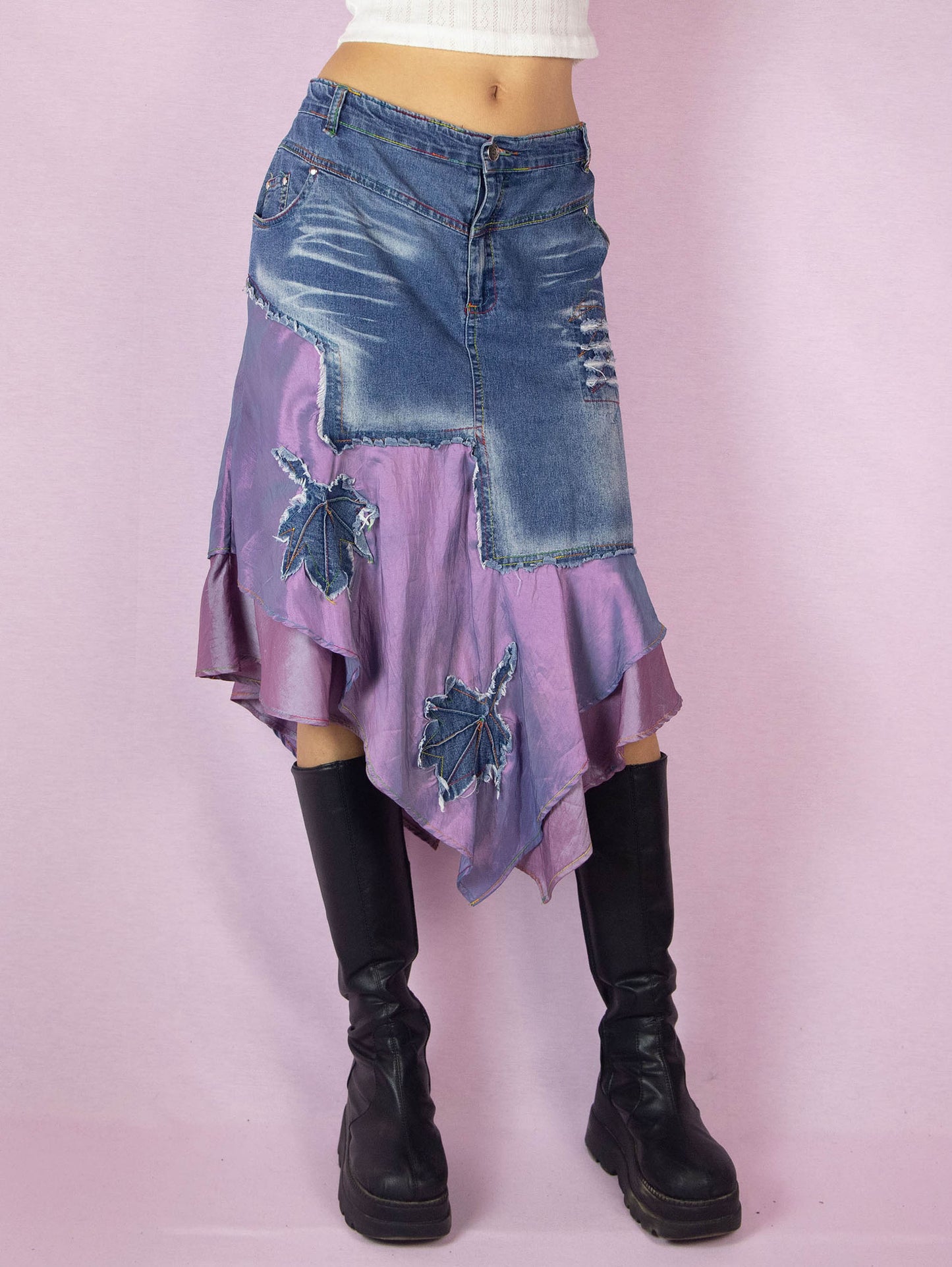 The Y2K Denim Asymmetric Trumpet Skirt is a vintage 2000s slightly stretchy jean midi skirt, avant-garde and deconstructed, with applique and acid wash details, a layered pointed hem, pockets, and a zipper closure.