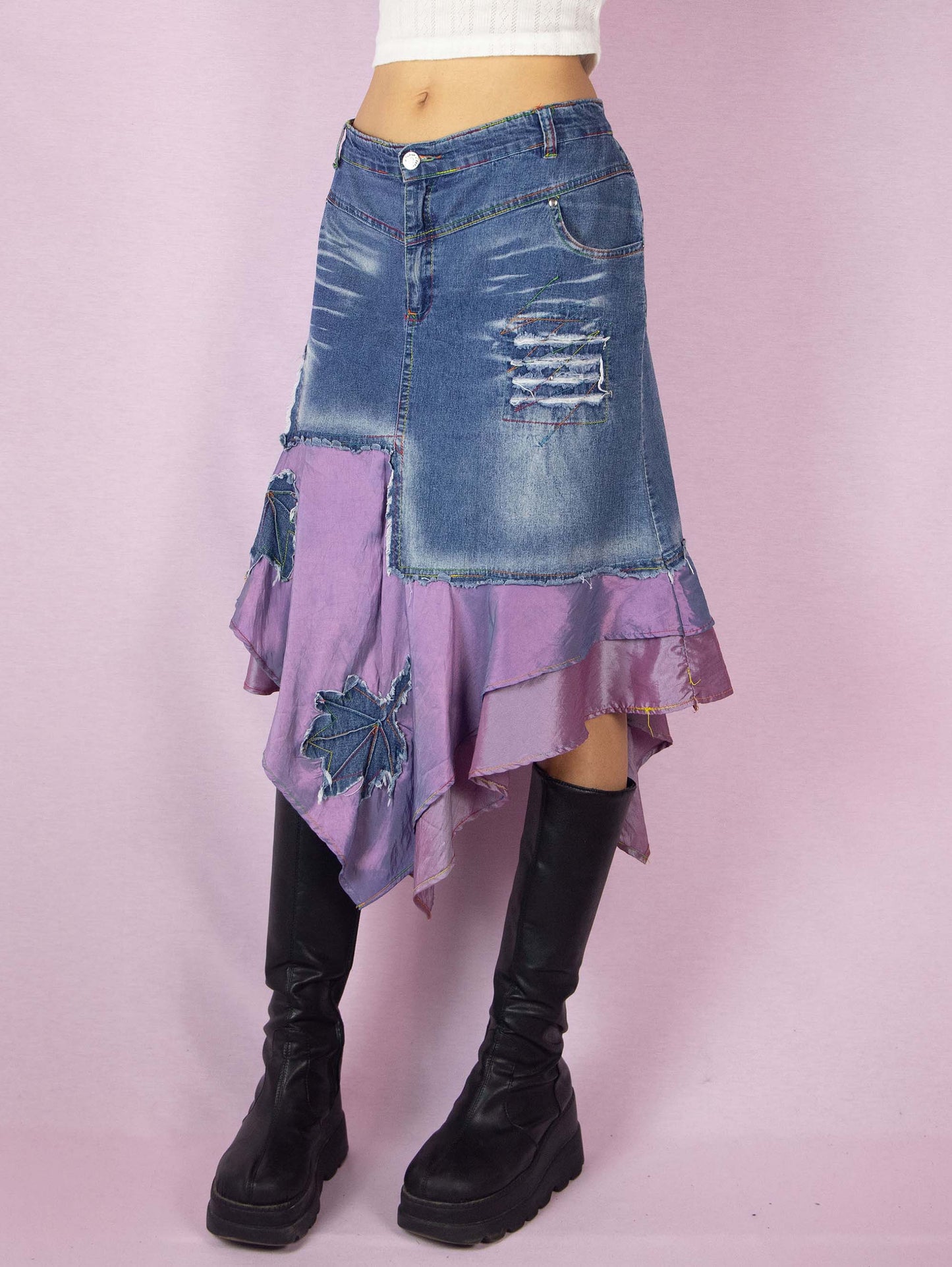 The Y2K Denim Asymmetric Trumpet Skirt is a vintage 2000s slightly stretchy jean midi skirt, avant-garde and deconstructed, with applique and acid wash details, a layered pointed hem, pockets, and a zipper closure.