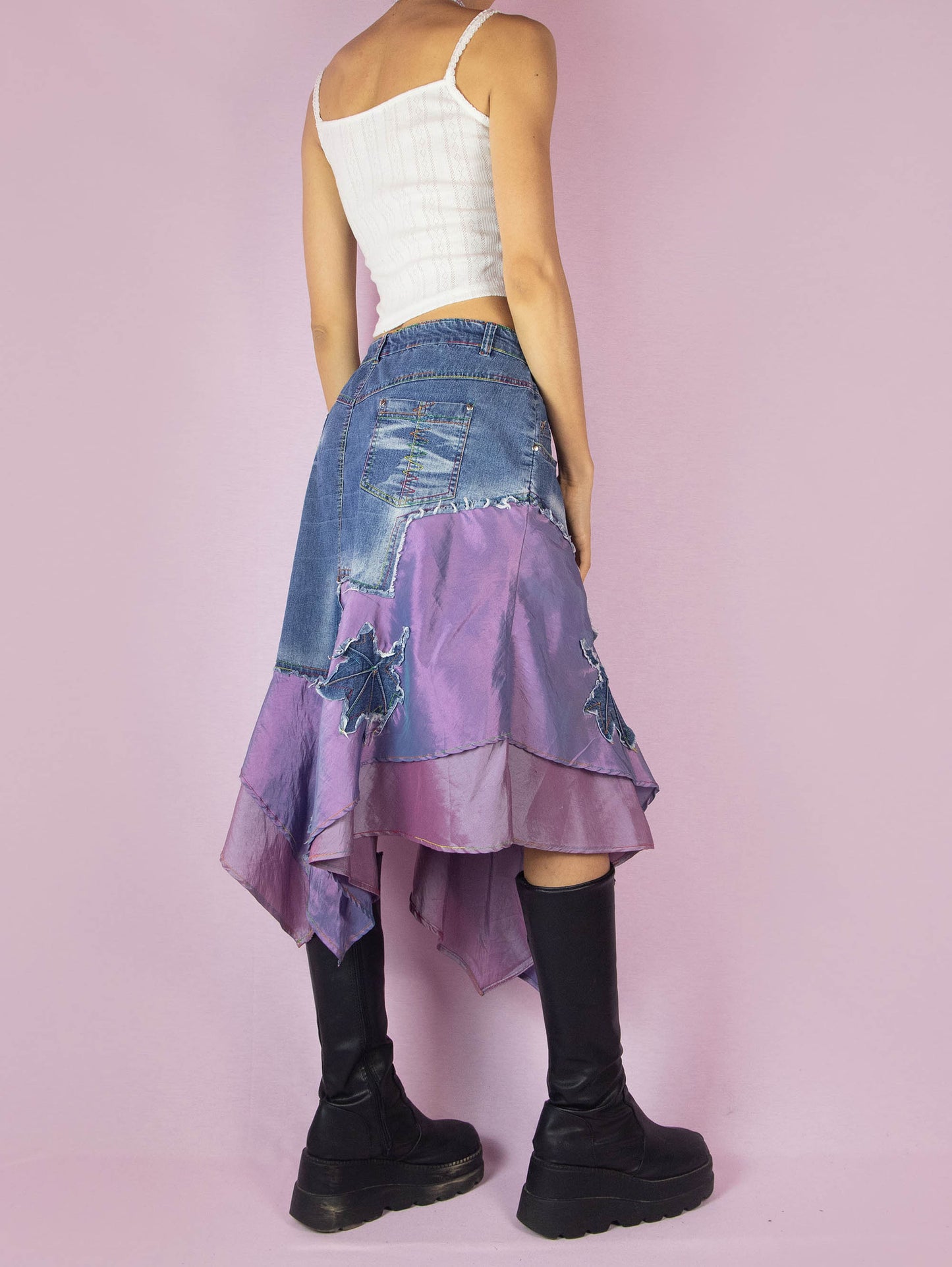 The Y2K Denim Asymmetric Trumpet Skirt is a vintage 2000s slightly stretchy jean midi skirt, avant-garde and deconstructed, with applique and acid wash details, a layered pointed hem, pockets, and a zipper closure.