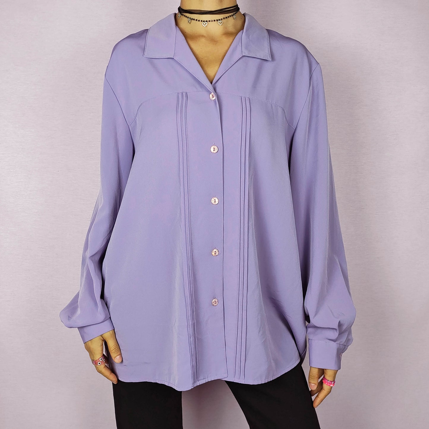 The Vintage 80s Lilac Blouse is a classic shirt featuring a soft, pastel purple hue. This long-sleeve blouse has pintuck details along the front and a pointed collar for an elegant look. The button-up design make it perfect for dressed up for formal occasions or worn casually.