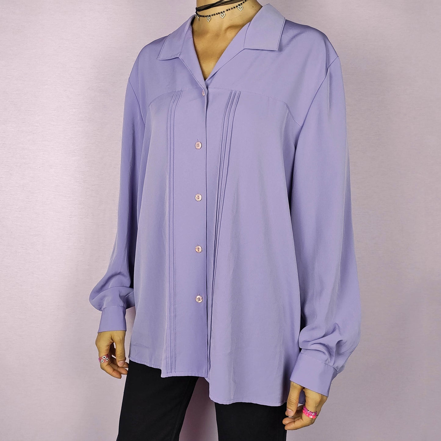 The Vintage 80s Lilac Blouse is a classic shirt featuring a soft, pastel purple hue. This long-sleeve blouse has pintuck details along the front and a pointed collar for an elegant look. The button-up design make it perfect for dressed up for formal occasions or worn casually.