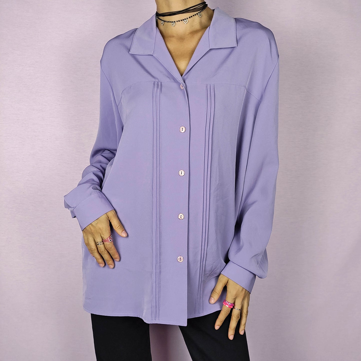 The Vintage 80s Lilac Blouse is a classic shirt featuring a soft, pastel purple hue. This long-sleeve blouse has pintuck details along the front and a pointed collar for an elegant look. The button-up design make it perfect for dressed up for formal occasions or worn casually.