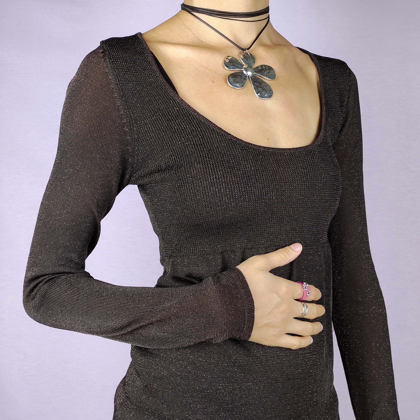 The Y2K Brown Sparkle Knit Top is a vintage 2000s piece, featuring a metallic thread woven throughout for a subtle shimmer, a scoop neckline and long sleeves, and is designed in a peplum style. Ideal for a night out or any autumn outfit.