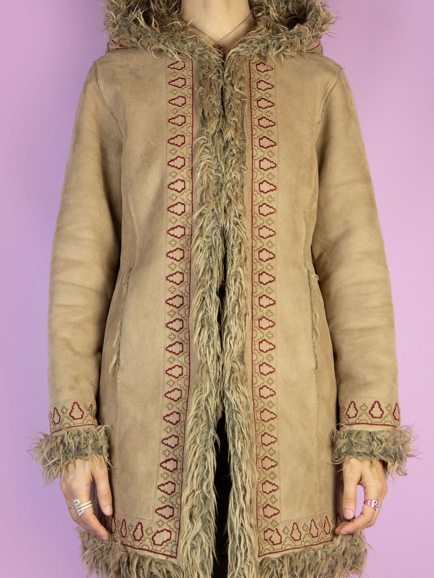 The Y2K Beige Hooded Afghan Coat is a vintage light brown beige faux suede coat with faux fur interior, collar, and cuffs. It also features a hood, pockets, and hook closure. Boho fairy grunge whimsygoth 2000s penny lane winter statement jacket.