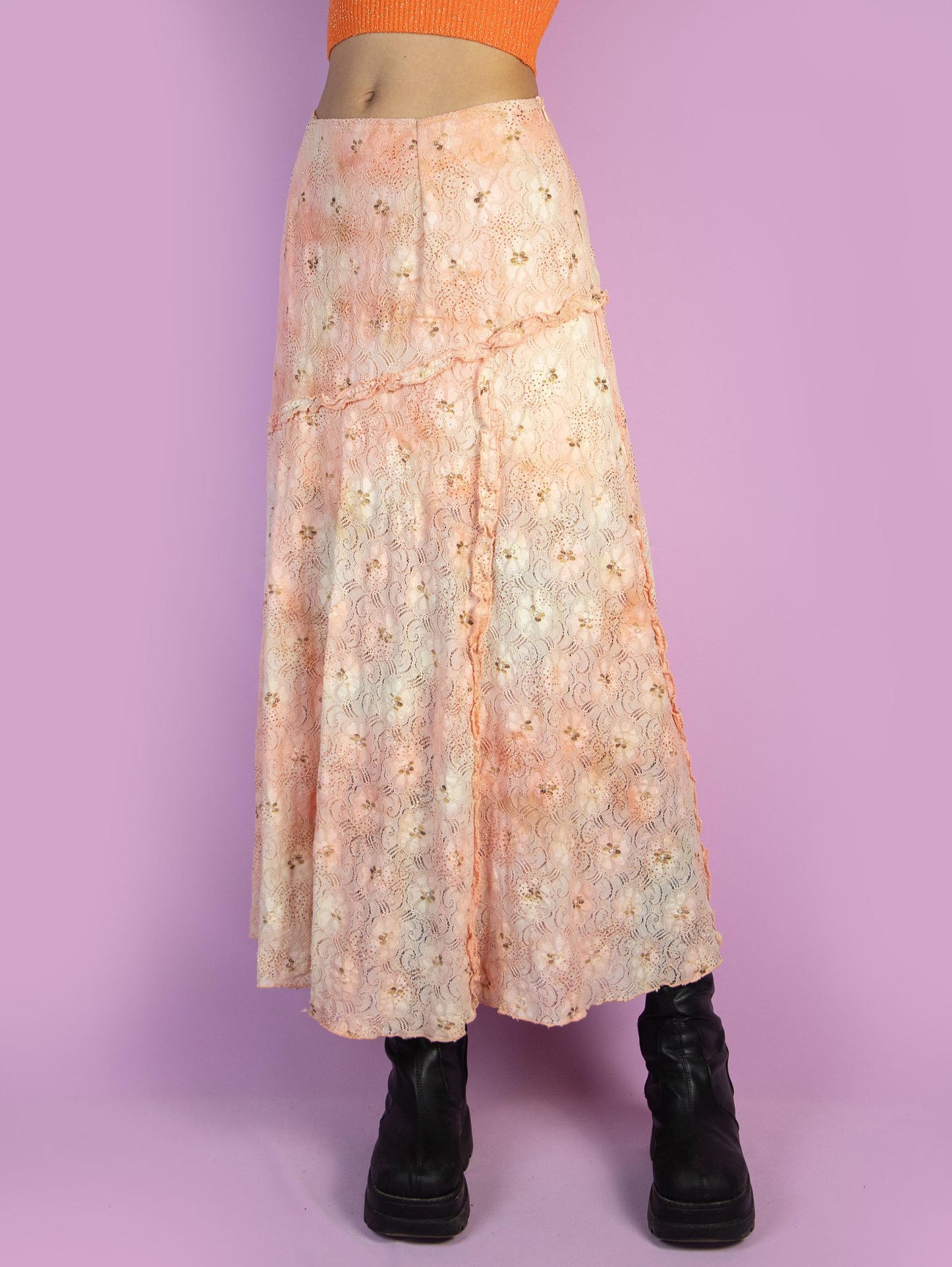 The Vintage 90s Fairy Orange Midi Skirt is a light orange and beige lace mesh skirt with glitter and ruffle details and a side zipper closure. Romantic boho 1990s pastel floral maxi skirt.
