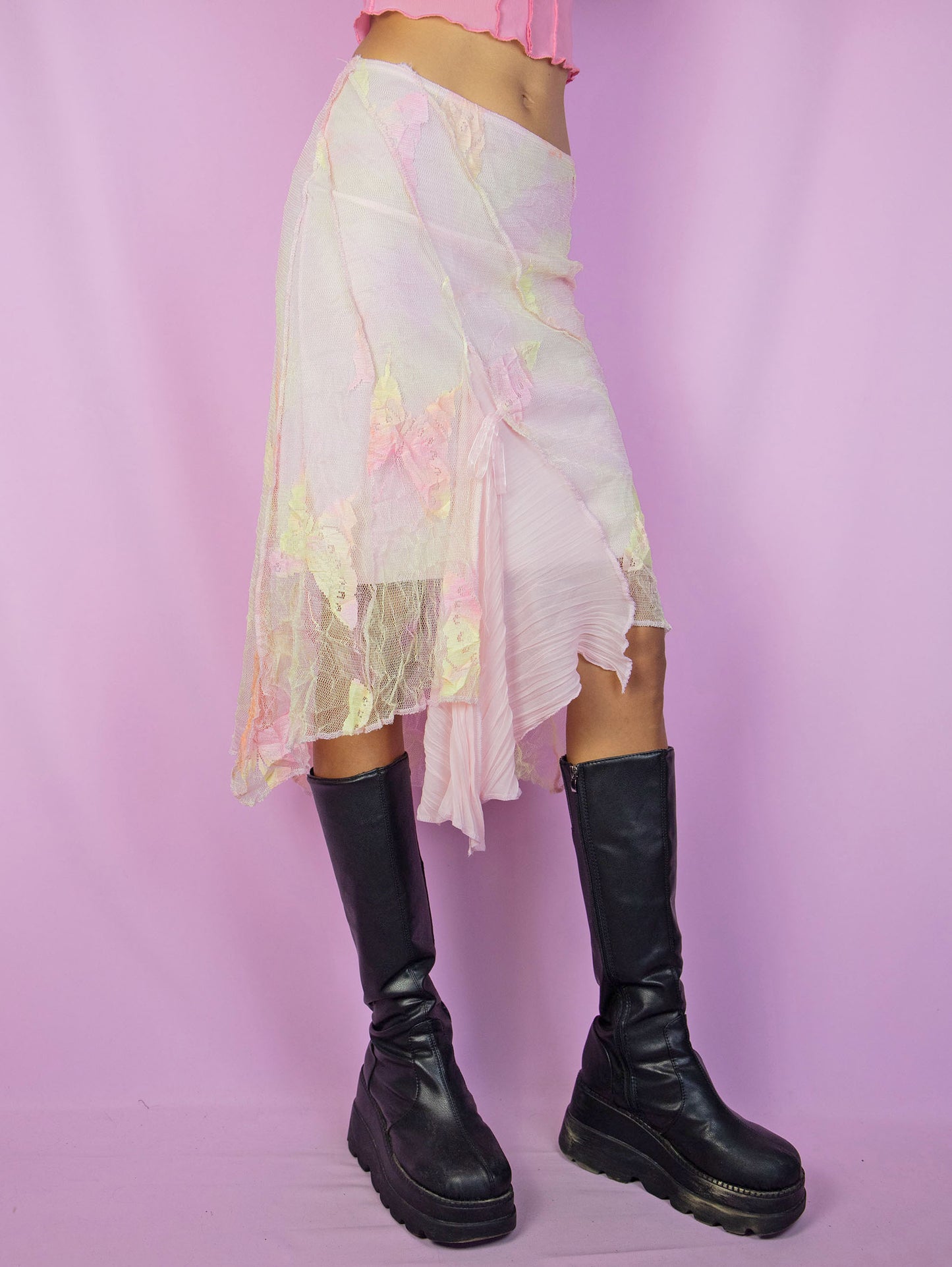 The Y2K Fairy Pink Midi Skirt is a vintage pastel pink, yellow, and orange tie-dye mesh skirt with floral details, an asymmetric hem, and an elastic waistband. A stunning avant-garde romantic coquette-style skirt from the 2000s.
