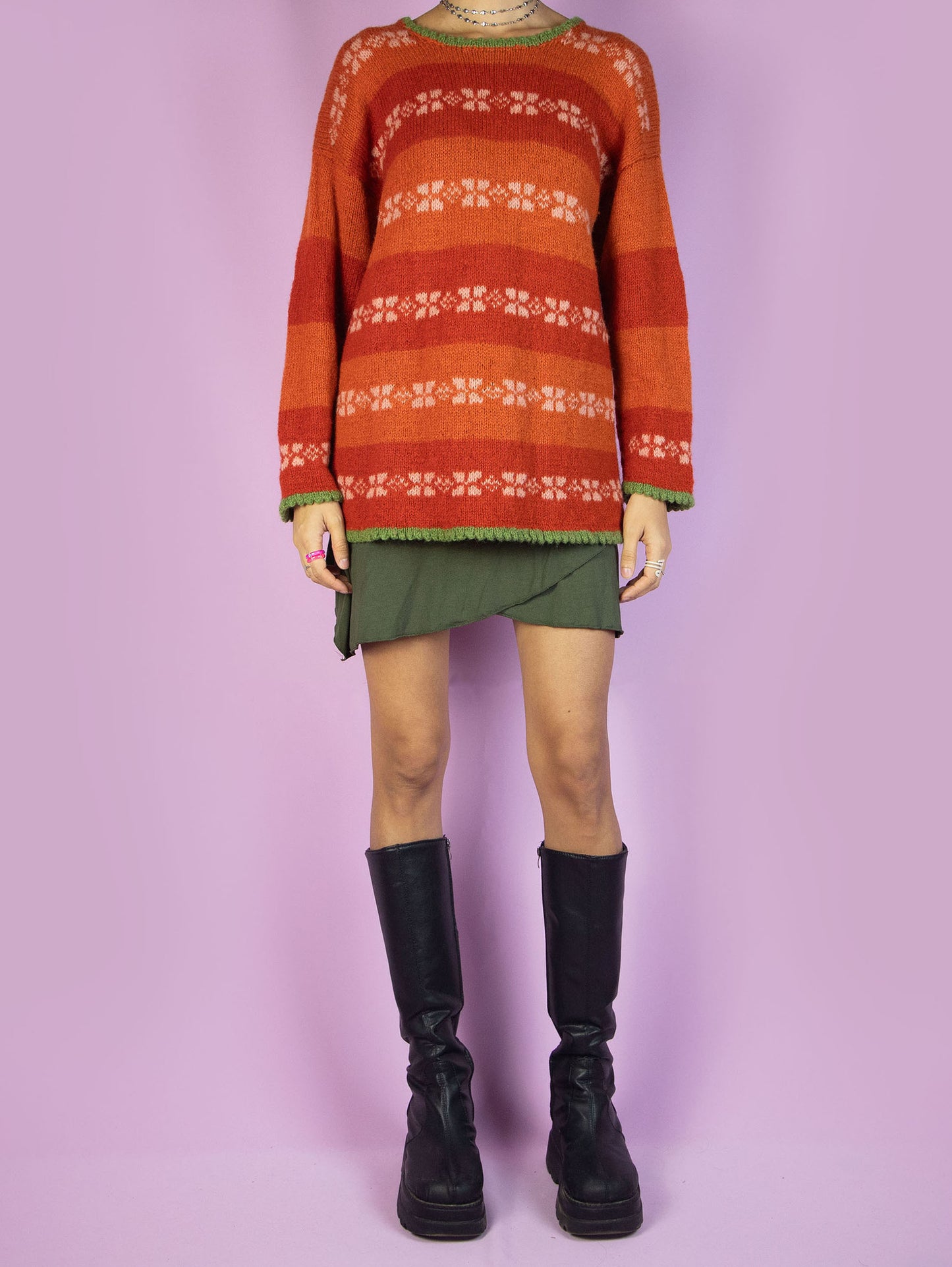 The Vintage 90s Orange Striped Sweater is a cozy winter pullover featuring multicolored stripes in shades of orange, white, and green. The sweater has a relaxed fit with a crew neckline and unique color-blocking. Perfect for adding a pop of color to any cold-weather outfit.