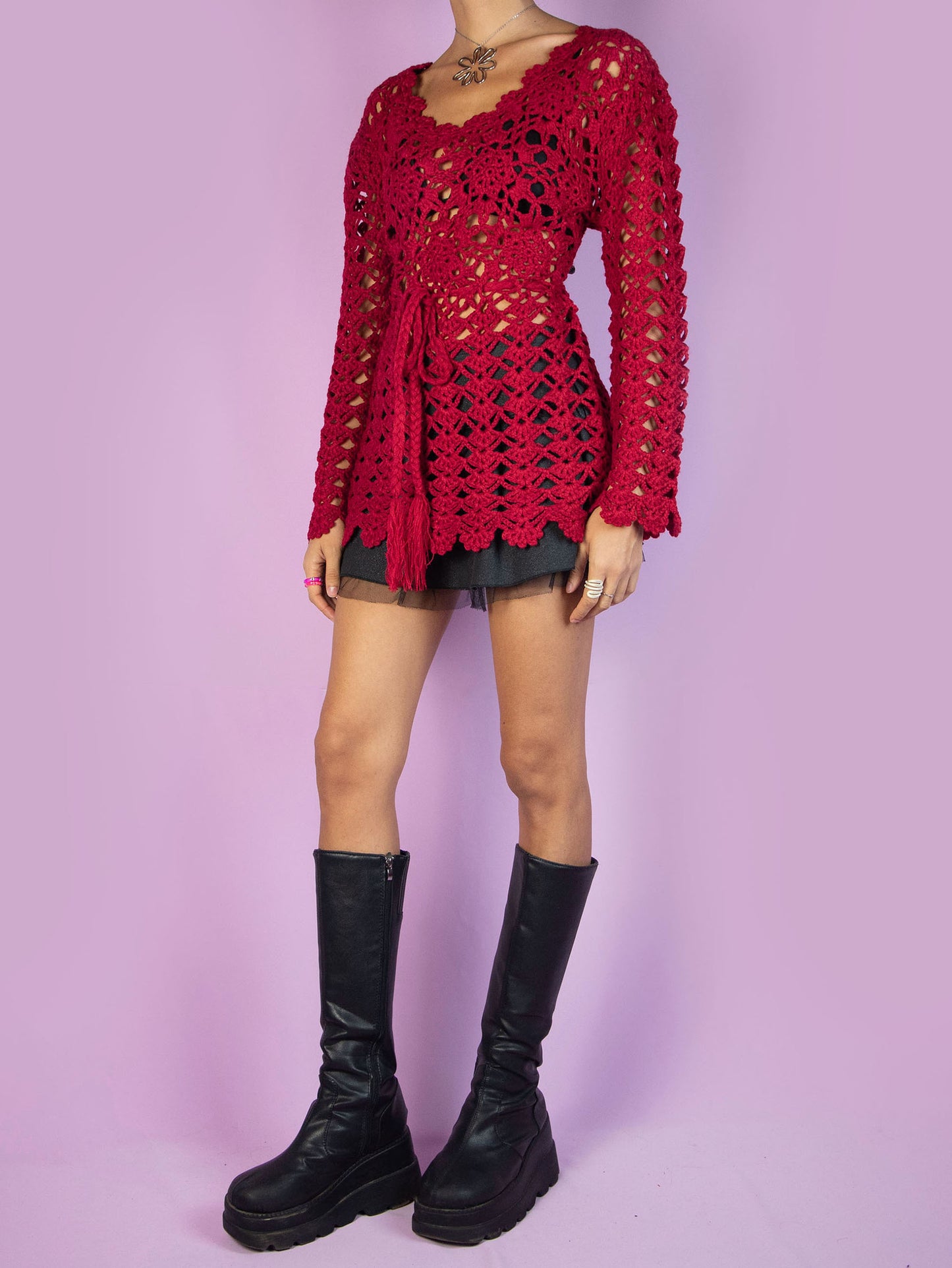 The Y2K Red Crochet Knit Sweater is a red crocheted knit top that ties at the waist and is made from a wool blend. Stunning romantic coquette boho 2000s pullover.