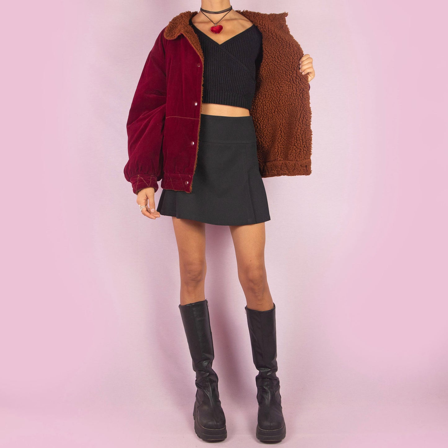 The Vintage 90s Red Velvet Bomber Jacket is a striking piece with a deep red velvet exterior featuring a contrasting brown faux shearling collar and inner lining. It includes snap button closures. Perfect for casual winter days or adding a bold touch to any outfit. Made in Italy.