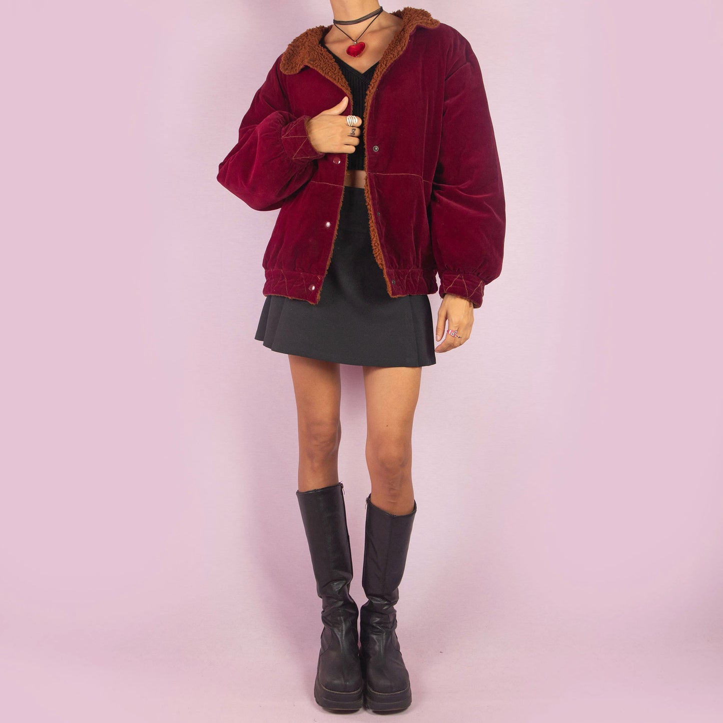 The Vintage 90s Red Velvet Bomber Jacket is a striking piece with a deep red velvet exterior featuring a contrasting brown faux shearling collar and inner lining. It includes snap button closures. Perfect for casual winter days or adding a bold touch to any outfit. Made in Italy.