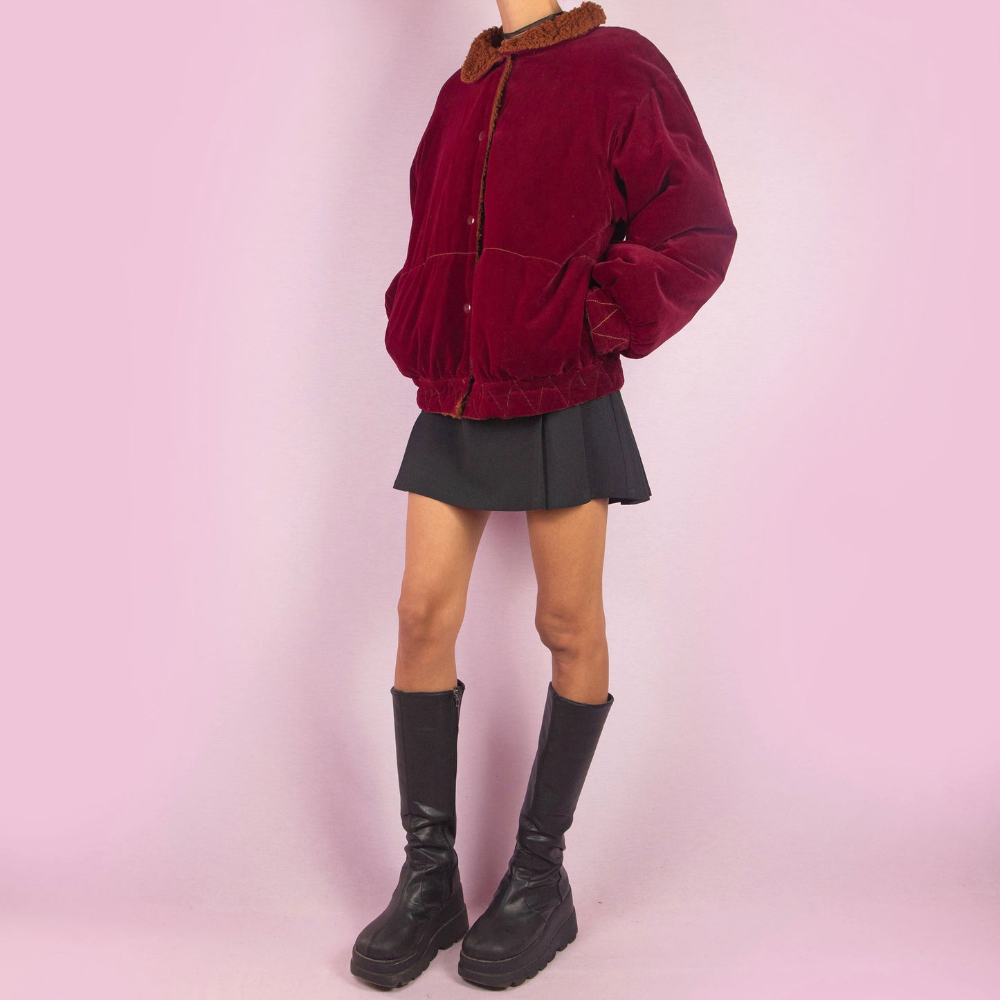 The Vintage 90s Red Velvet Bomber Jacket is a striking piece with a deep red velvet exterior featuring a contrasting brown faux shearling collar and inner lining. It includes snap button closures. Perfect for casual winter days or adding a bold touch to any outfit. Made in Italy.