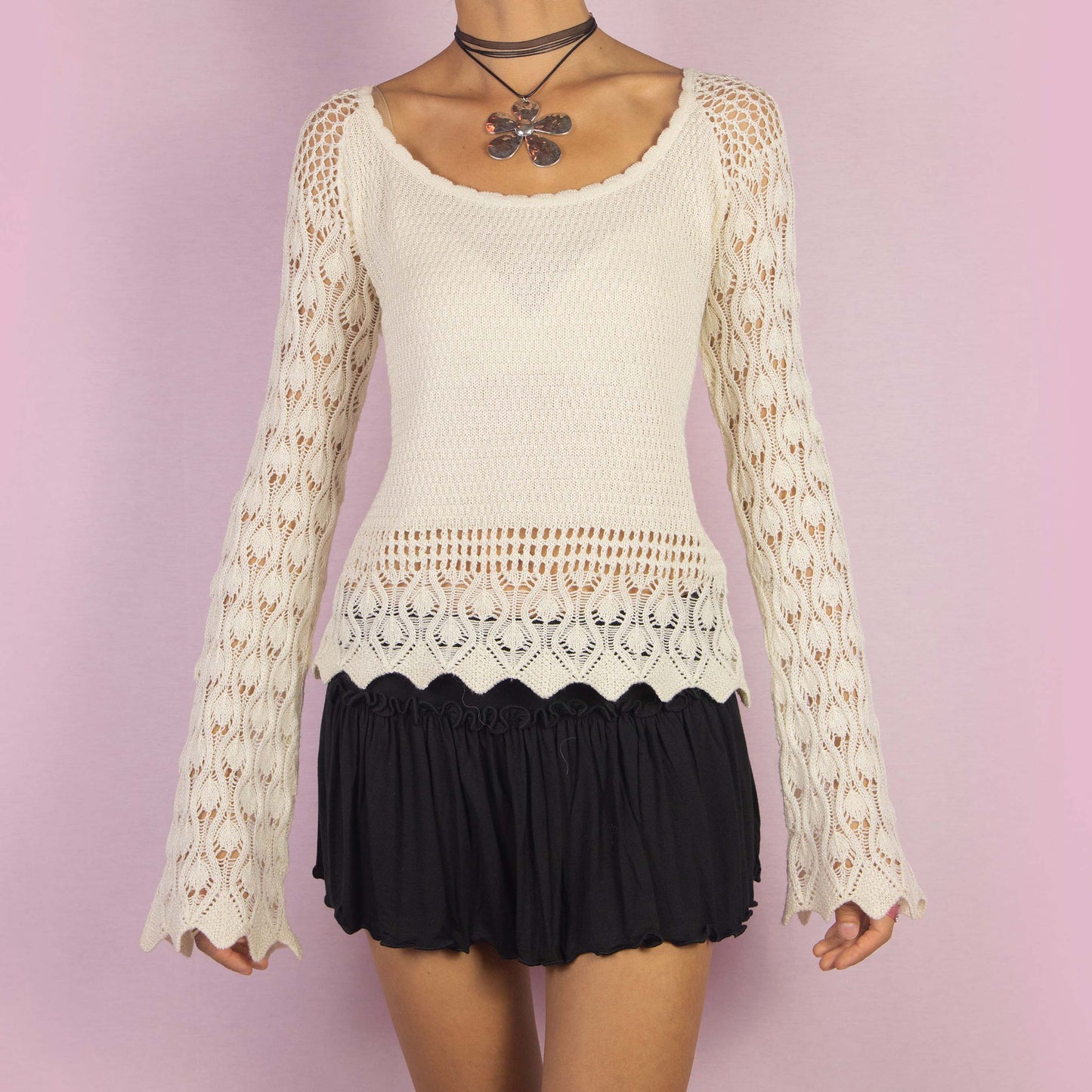 The Y2K Cream Bell Sleeve Sweater is a vintage 2000s white stretchy pullover featuring an intricate open-knit crochet design and long flared sleeves. Perfect for casual autumn days.