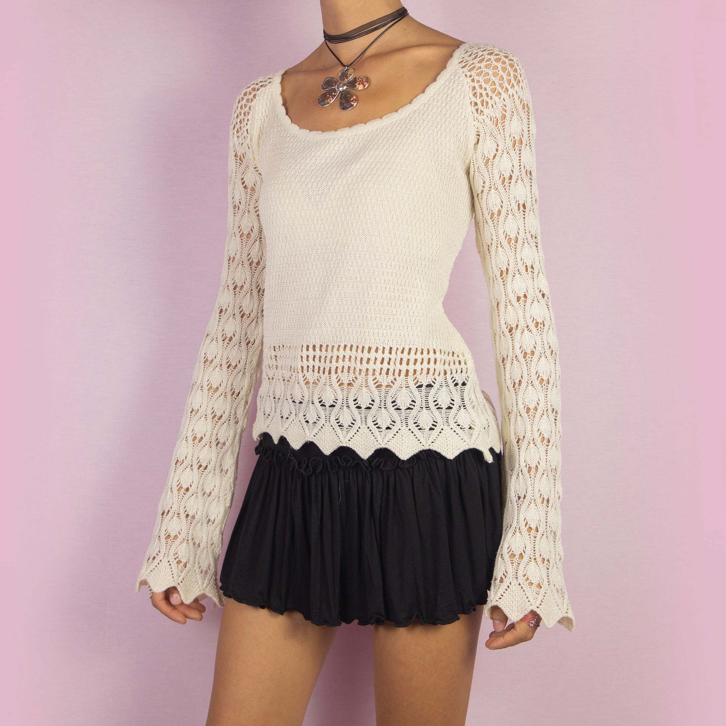 The Y2K Cream Bell Sleeve Sweater is a vintage 2000s white stretchy pullover featuring an intricate open-knit crochet design and long flared sleeves. Perfect for casual autumn days.