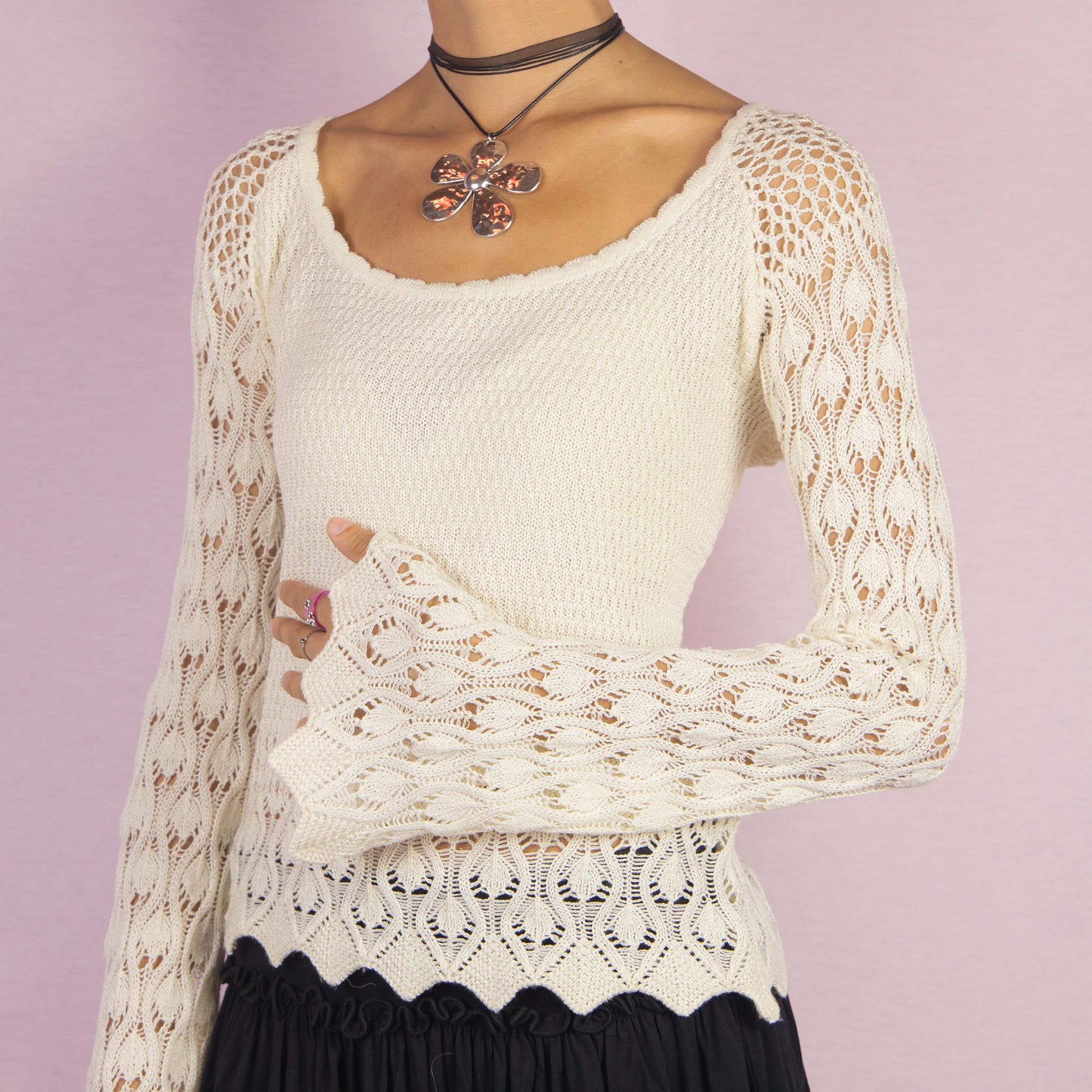 The Y2K Cream Bell Sleeve Sweater is a vintage 2000s white stretchy pullover featuring an intricate open-knit crochet design and long flared sleeves. Perfect for casual autumn days.