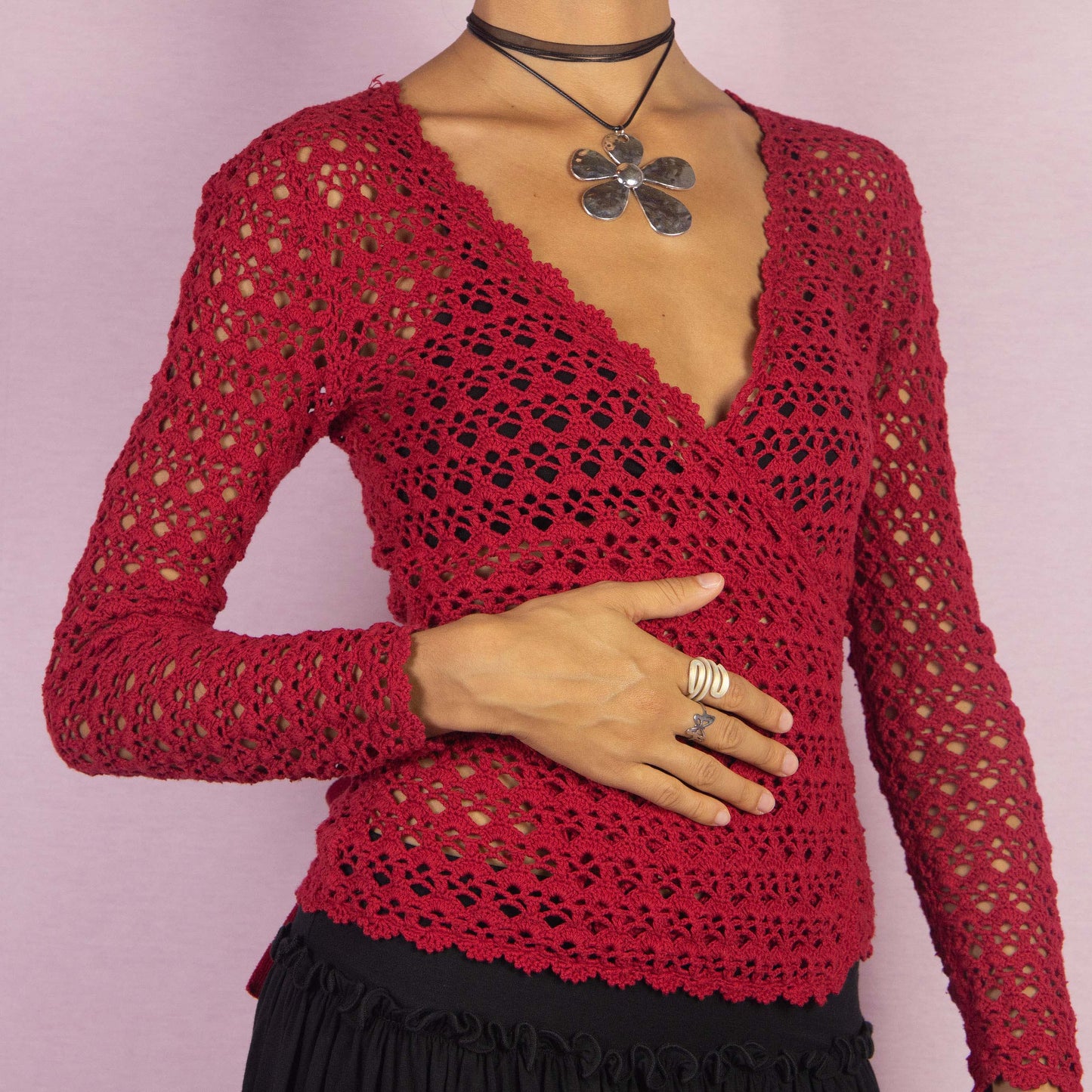 The Y2K Red Crochet Wrap Cardigan is a vintage 2000s piece featuring a romantic deep V-neckline with an intricate open-knit design. Its wrap style and tie closure at the back form a stylish bow, creating a flattering silhouette. Perfect for layering in spring and summer.