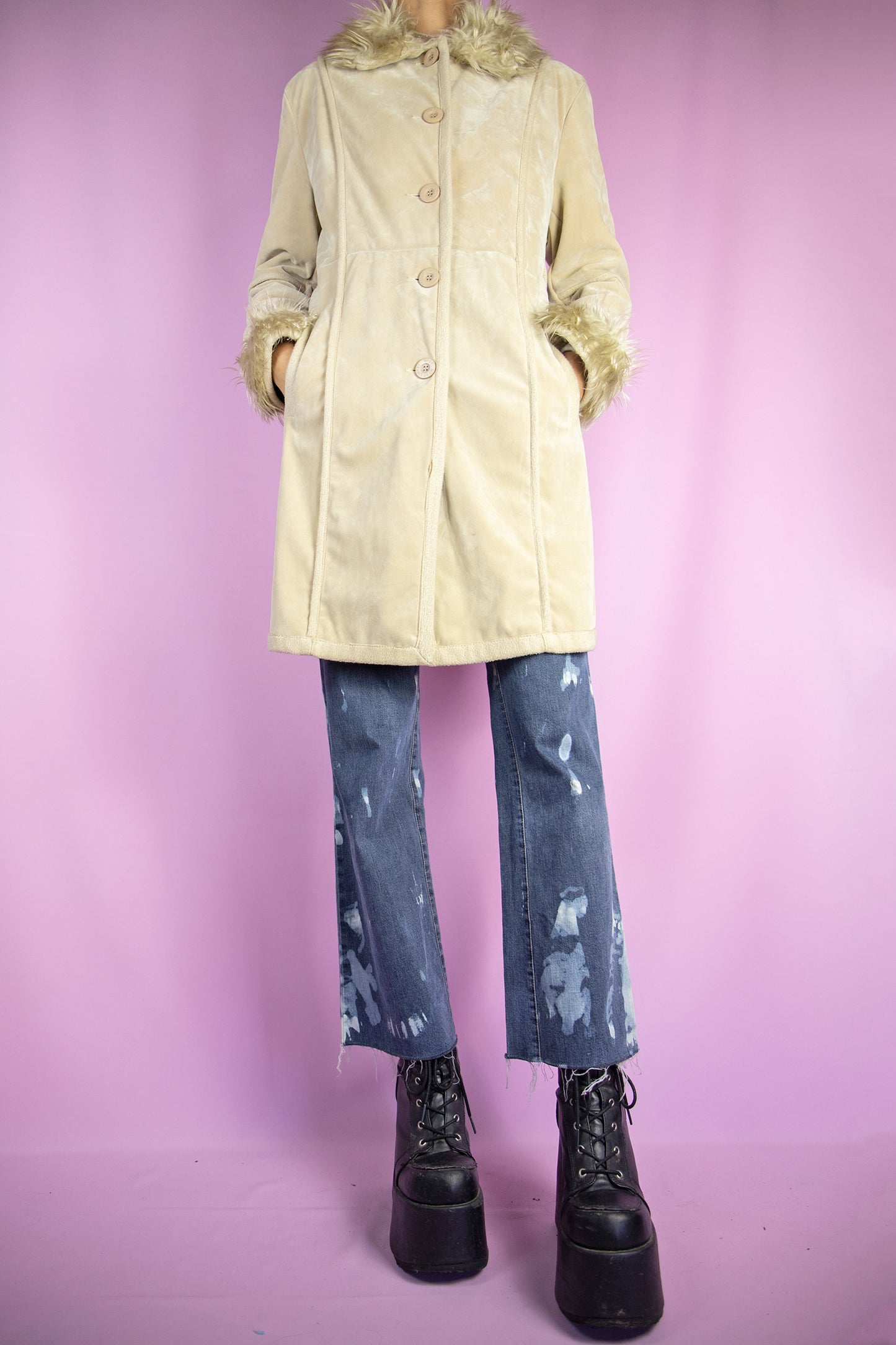 The Y2K Beige Penny Lane Jacket is a vintage 2000s winter faux suede statement coat showcasing faux fur collar and cuffs, along with pockets, buttons, and a coordinating belt.