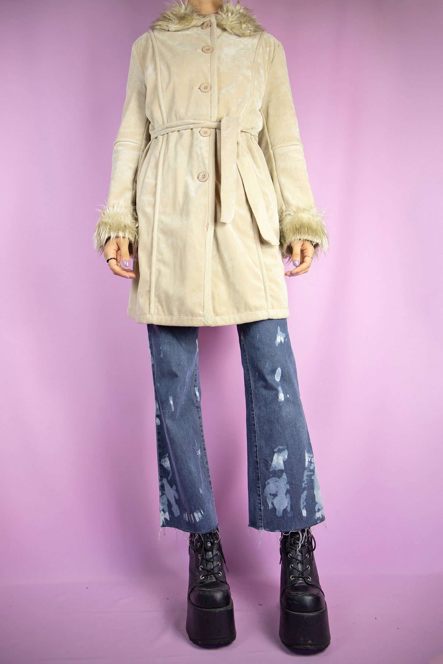 The Y2K Beige Penny Lane Jacket is a vintage 2000s winter faux suede coat featuring a faux fur collar and cuffs, pockets, buttons, and a coordinating belt. Iconic in style, it’s perfect for both casual wear and party outfits.