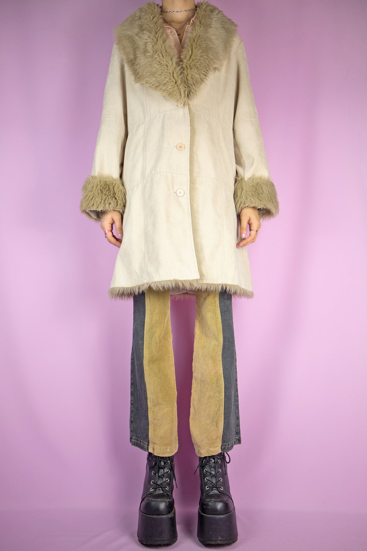 The Y2K Beige Penny Lane Coat is a vintage 2000s faux suede jacket featuring light brown faux fur collars and cuffs, a button closure, and pockets. Iconic and elegant with a boho flair, it’s perfect for winter looks.
