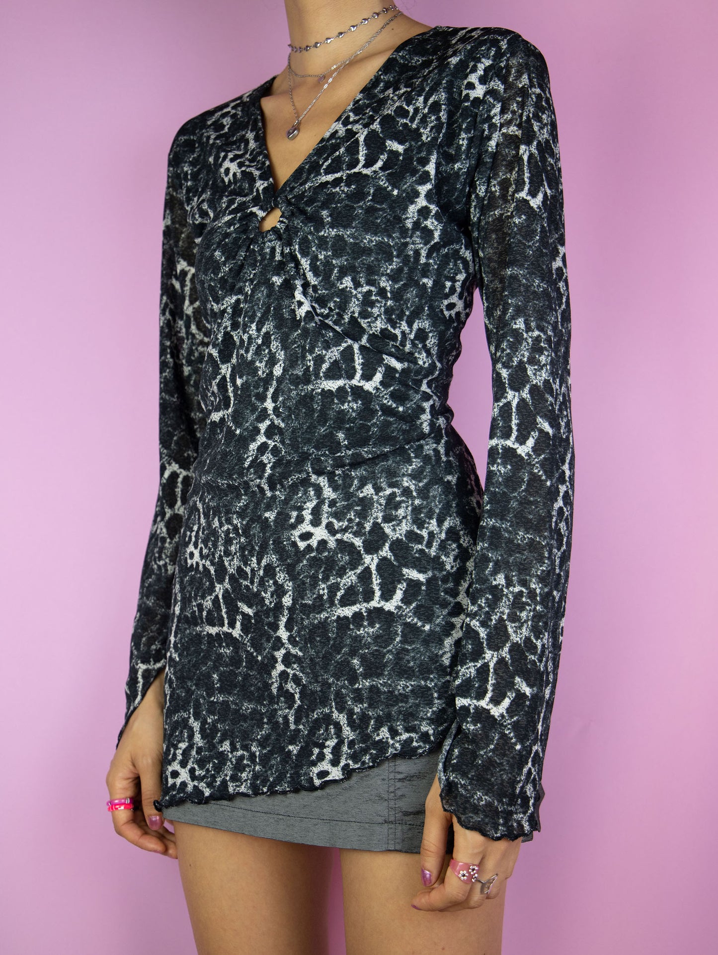 The Y2K Printed Mesh Asymmetric Top is a vintage 2000s cyber party black, gray and white semi-sheer shirt with leopard animal print and ruched front with o-ring detail.