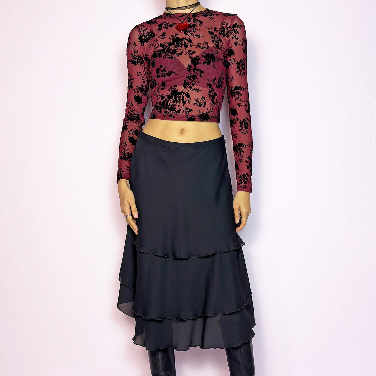 The Vintage 90s Black Layered Tiered Skirt features a flowy, tiered design with cascading chiffon-like layers. It includes a side zipper closure. Its versatile length and elegant style make it perfect for both casual outings and evening parties. Excellent vintage condition.