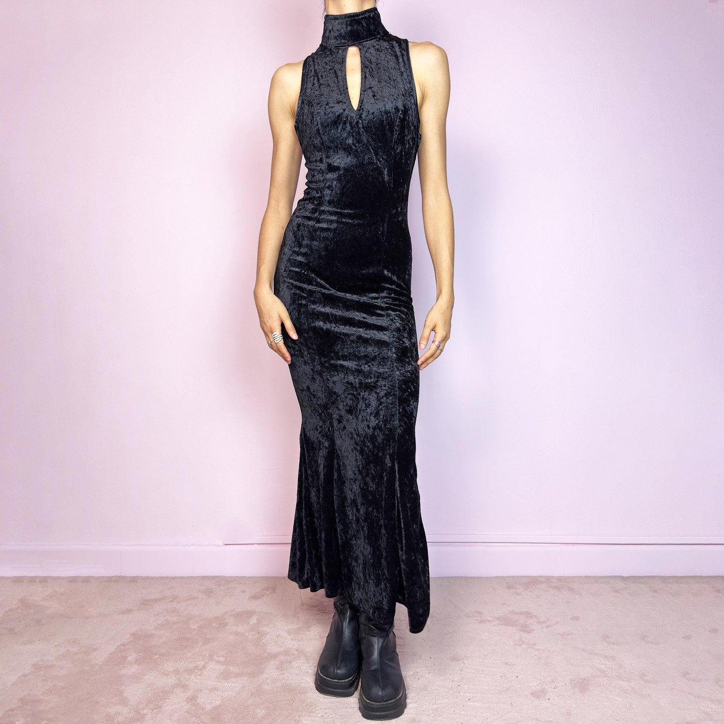 This vintage 90s black maxi dress is cut from plush stretch velvet with a sleeveless silhouette, mock neck, and front keyhole cut-out. Designed with a curve-hugging fit, ankle length, and back zipper closure. The soft texture and sculpted lines create bold contrast and gothic elegance. A sultry minimalist piece with timeless evening allure—perfect for formal events or moody romantic nights. Great vintage condition.