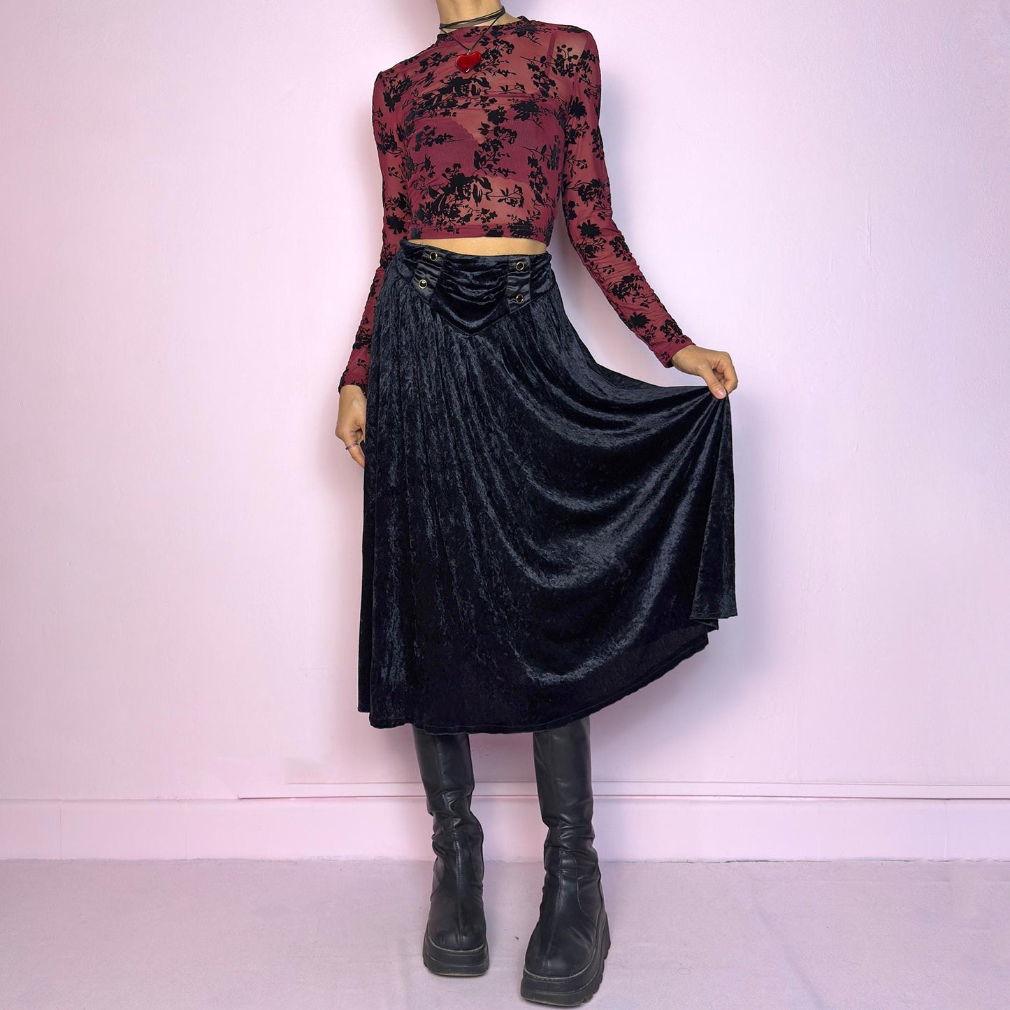The Vintage 90s Black Velvet Midi Skirt is crafted from soft velvet and features an elastic waistband detail with button accents and a flowing A-line silhouette. Ideal for night parties and embodies a whimsical goth aesthetic. Adult World Shop