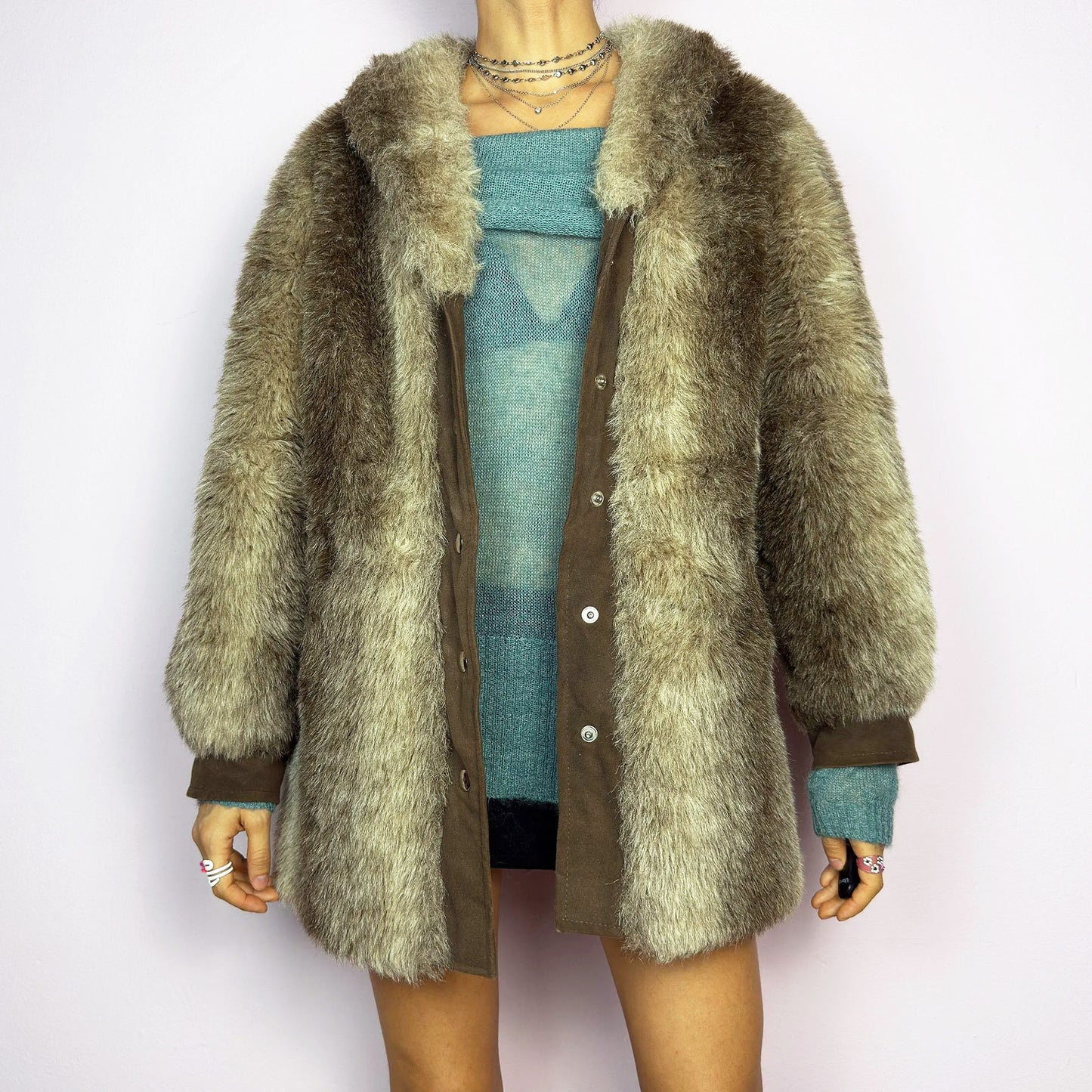 The Vintage 90s Plush Faux Fur Coat is a statement outerwear piece exuding warmth and glamour. This coat features a plush faux fur texture in earthy tones, creating a cozy look. Designed with a snap button-front closure, pockets and long sleeves, this coat is perfect for chilly days and for layering over casual or dressy outfits.