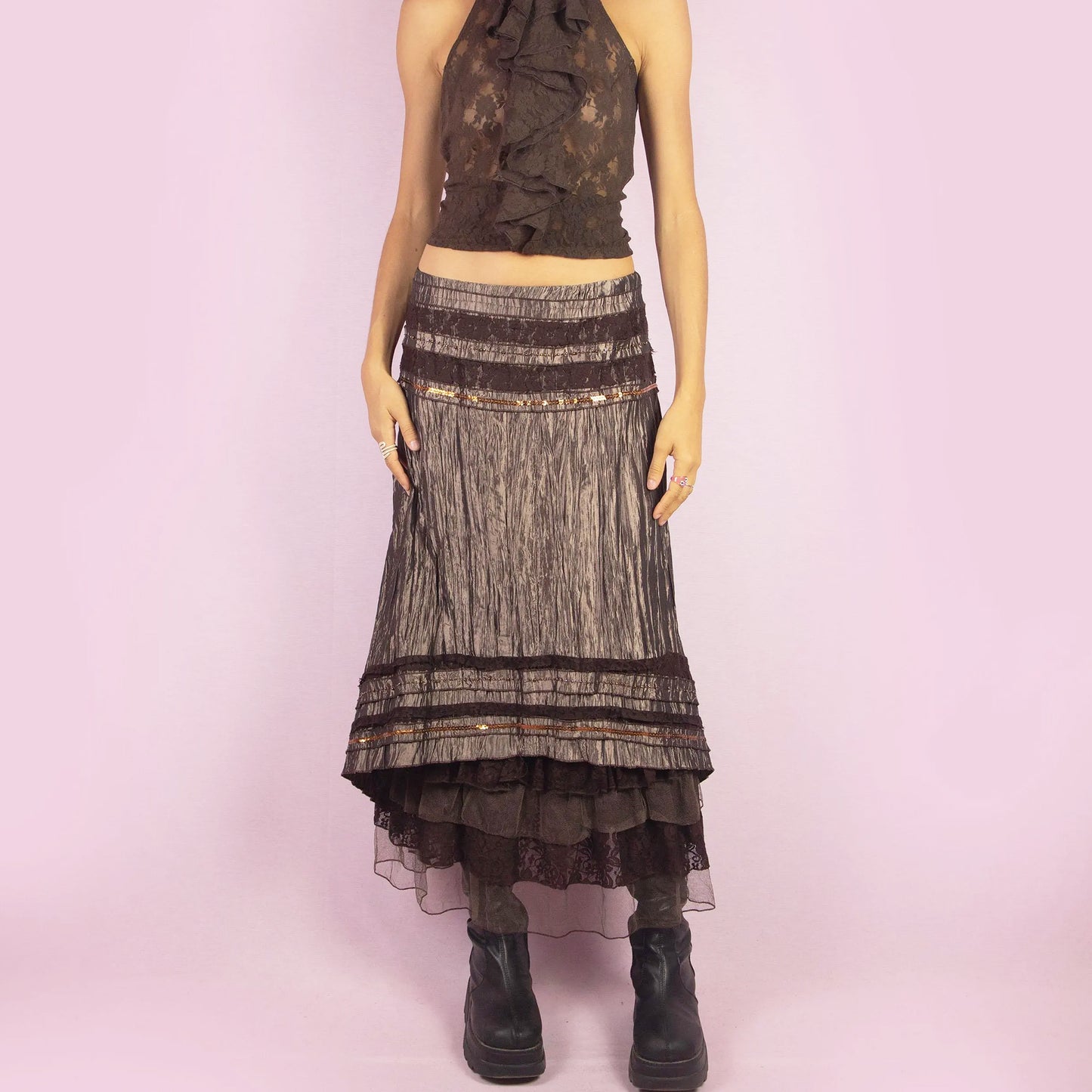 The Y2K Brown Layered Midi Skirt is a vintage 2000s piece featuring an earthy brown palette with a mix of crinkled fabric, lace, and mesh layers. The mid-waisted design and asymmetrical hemline create a flowy, bohemian silhouette, with a side zipper closure. Perfect for casual outings or whimsical evening looks.