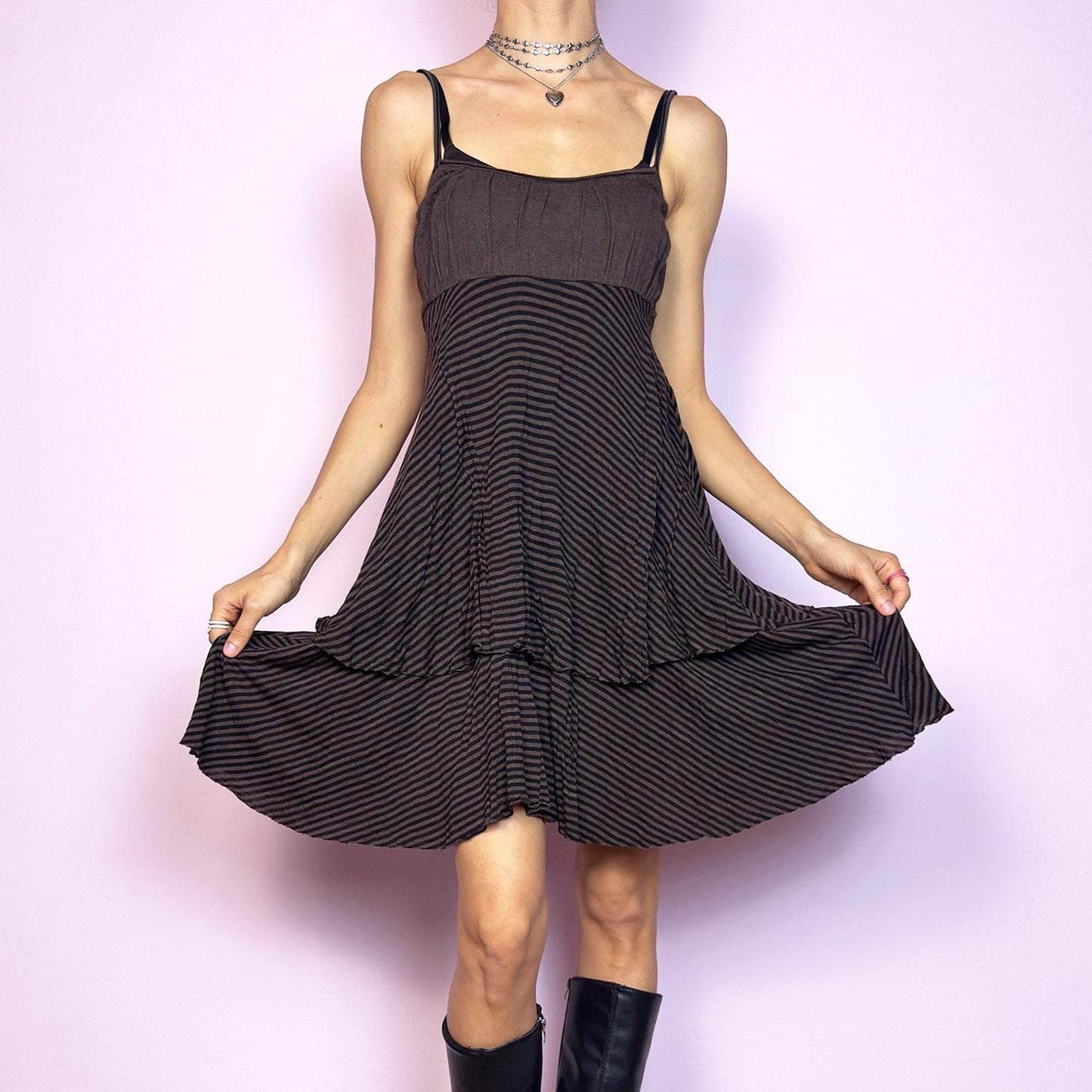 This vintage 2000s brown midi dress features a fine black stripe pattern, square neckline, and thin shoulder straps. Made from a soft, stretchy knit, it has an empire waist and a tiered asymmetric hem that drapes with ease. Perfect for summer. A casual, fairy grunge–inspired piece with subtle volume and flow—blending comfort, minimalism, and quiet edge. Great vintage condition.