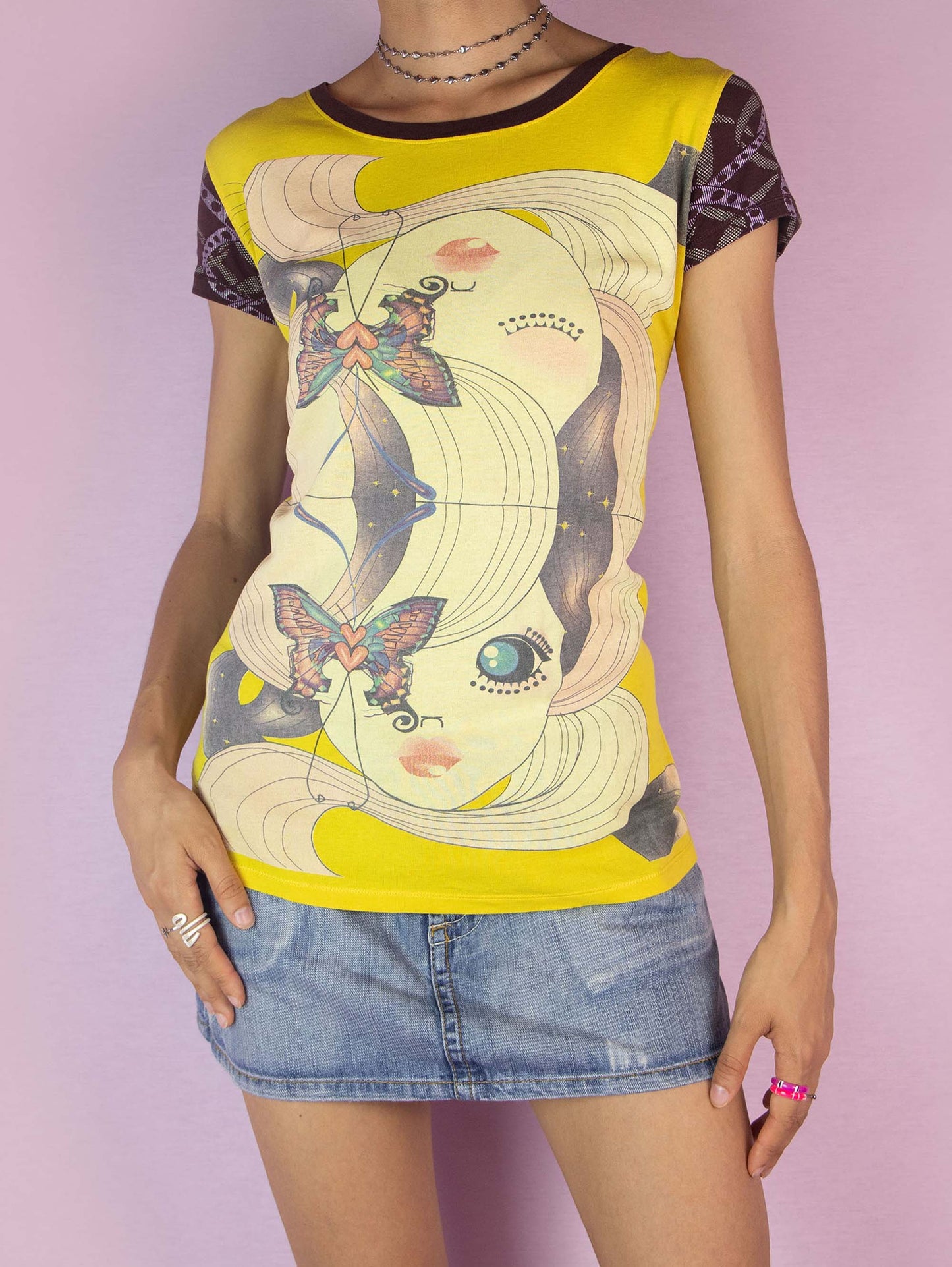 The Y2K Custo Barcelona Graphic Top is a vintage 2000s t-shirt featuring a vibrant multicolored graphic on the front and intricate print details on the short sleeves. The back showcases additional graphic elements. Perfect for a casual summer look.