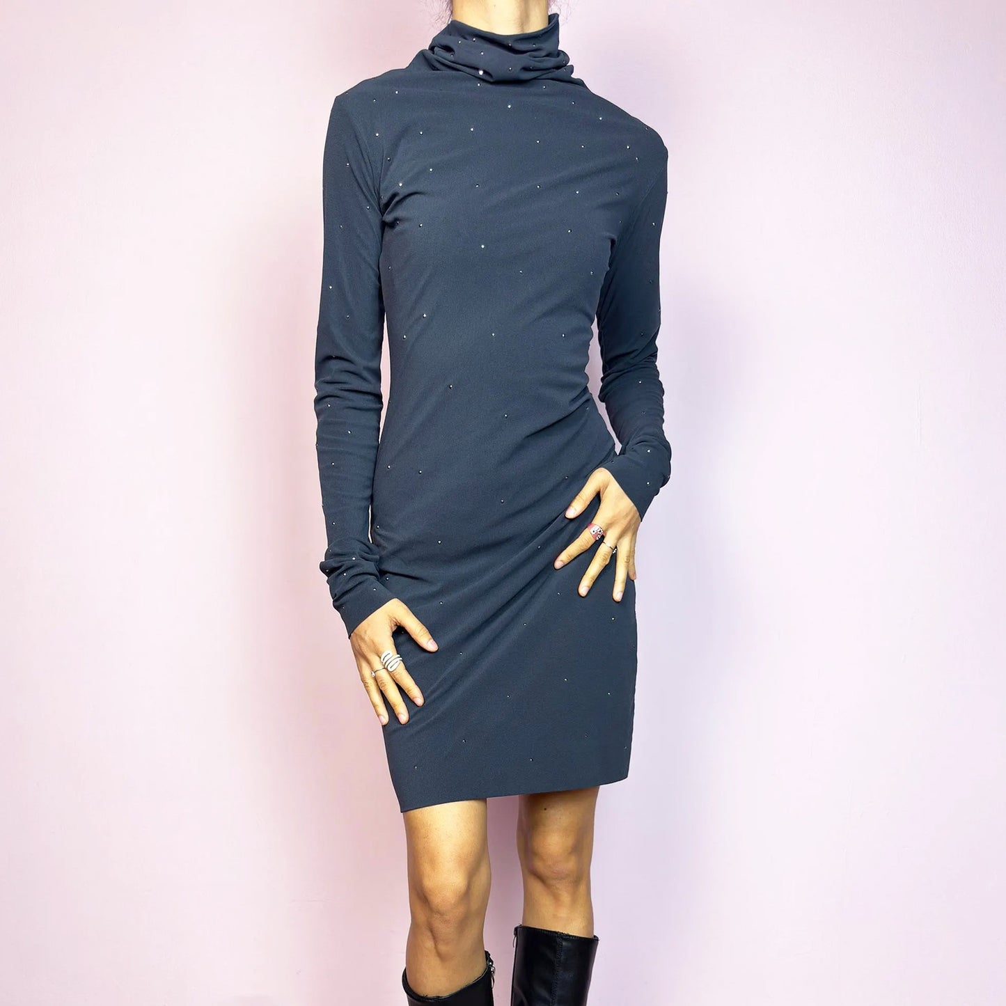 This vintage 2000s grey mini dress is cut from stretchy mesh jersey with an elegant turtleneck and long sleeves. Subtle rhinestones are scattered throughout, catching light with a soft shimmer. The bodycon silhouette hugs the figure with ease. No closure, easy pull-on style. A minimalist Y2K piece with glam undertones—perfect for winter nights, parties, or city outings. Made in Italy. Excellent vintage condition.