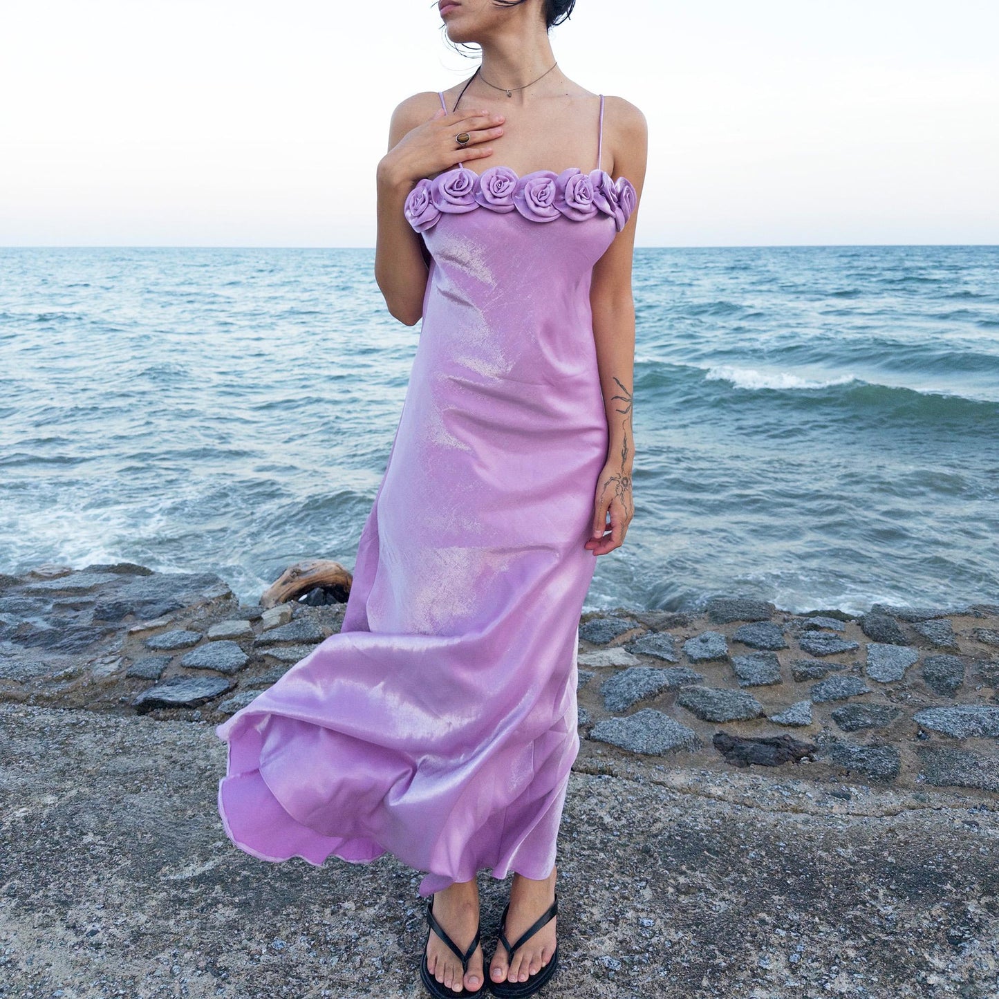 The vintage 2000s pastel lilac slip dress is a French-made fantasy with sculptural rosette appliqué along the bust. Its iridescent finish and fluid midi length evoke dreamy softness, perfect for proms, summer weddings, or romantic evenings. The silhouette captures fairytale allure with quiet glamour. A romantic Y2K archive crafted from a shimmering non-stretch polyester blend fabric. Excellent vintage condition.