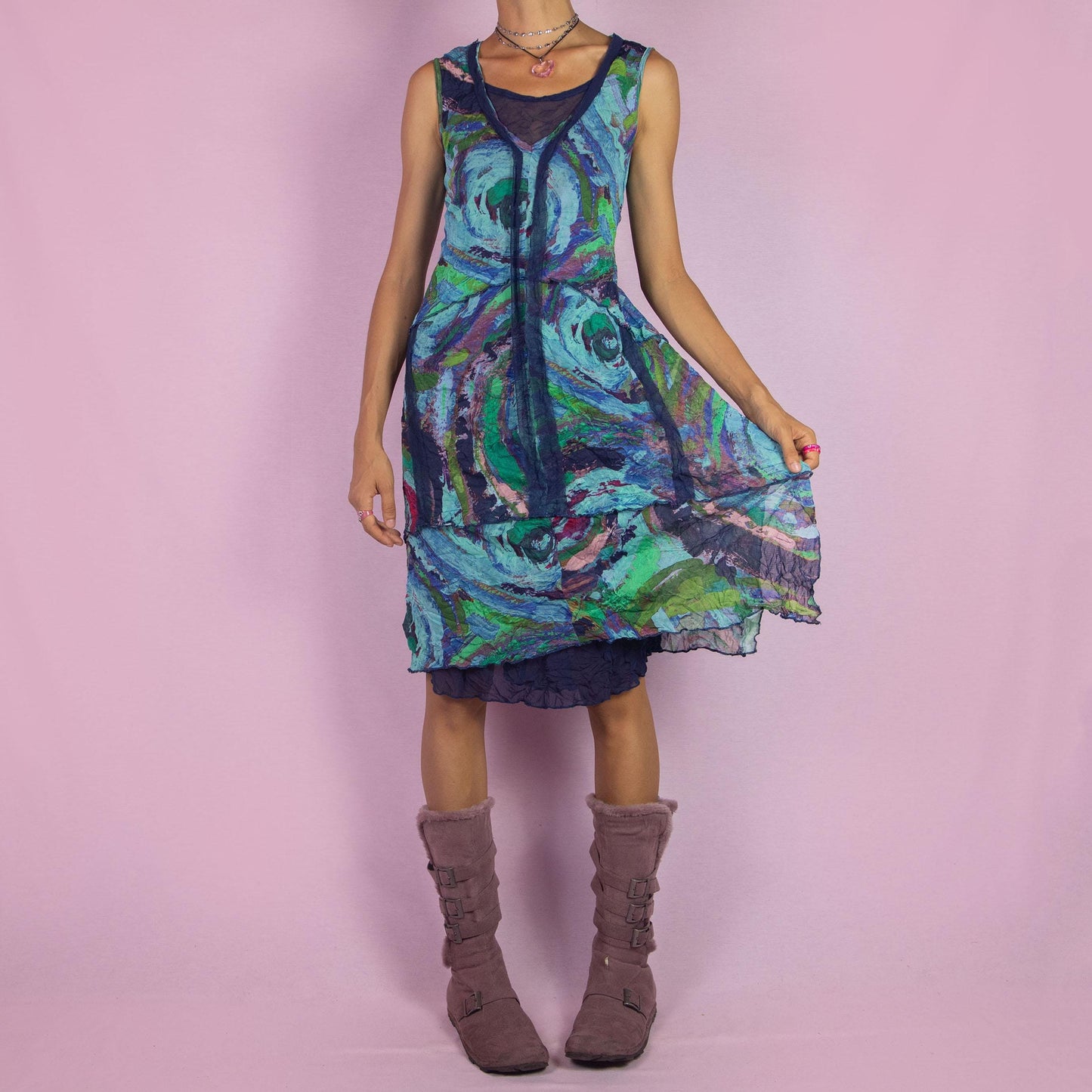 The Y2K Art Print Mesh Dress is a vintage 2000s piece featuring a flowing A-line silhouette with an abstract, artistic print in vibrant tones of blue, green, and purple. Crafted from lightweight, semi-sheer mesh fabric, it offers a layered design
