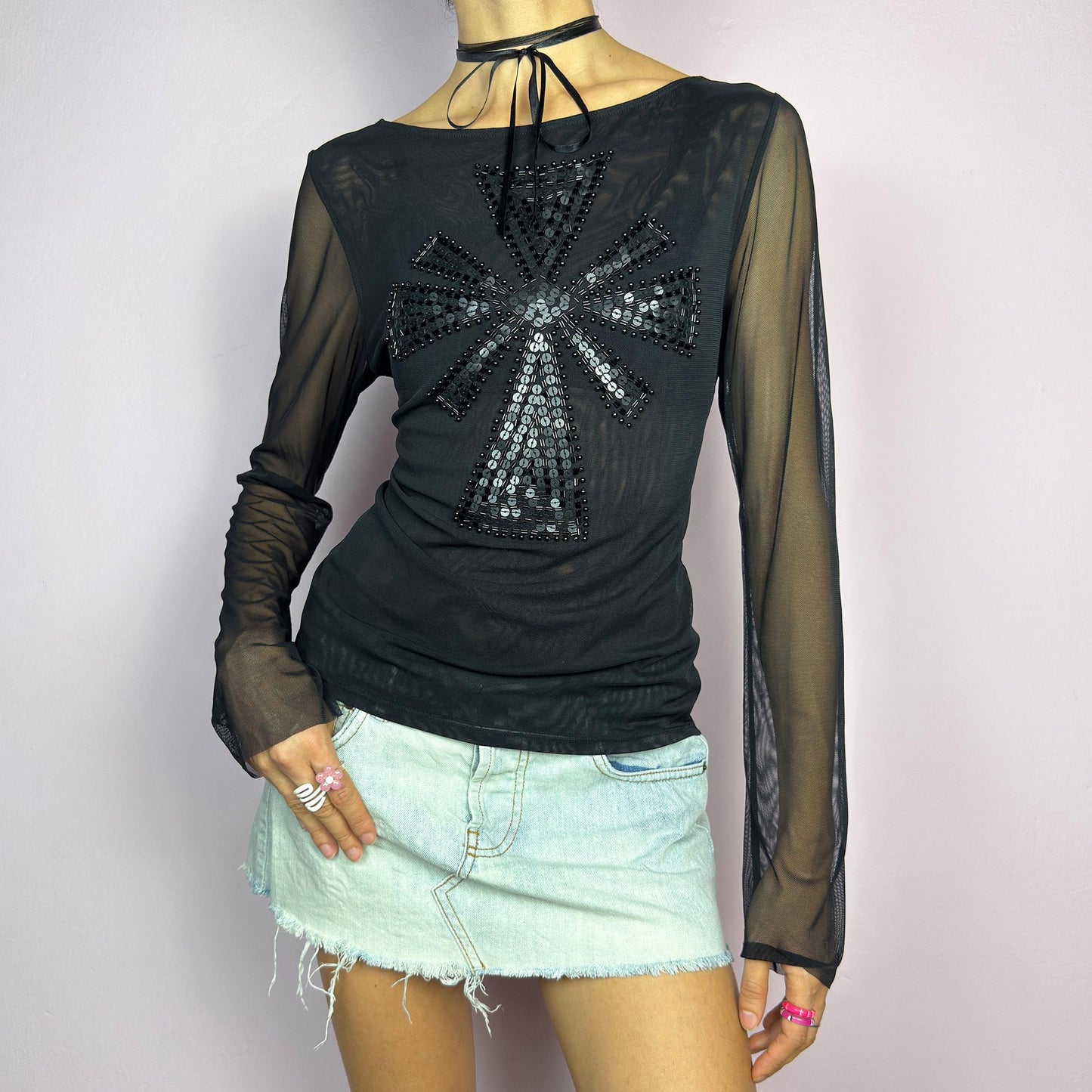 The Y2K Black Embellished Mesh Top is a statement vintage 2000s piece. This sheer top features a bold black sequin and bead embellishment in a striking cross pattern on the front. The lightweight mesh fabric and long sleeves. adult world shop