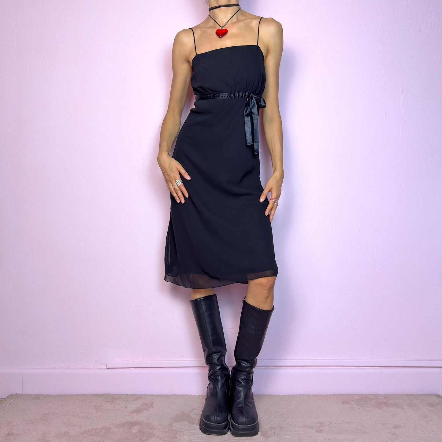 The Y2K Black Slip Midi Dress is a vintage 2000s dreamy minimalist piece featuring a lightweight sheer overlay, spaghetti straps, a flattering empire waist with a satin tie, and a classic midi silhouette. The lightweight, flowy fabric creates beautiful movement, making it perfect for party looks and romantic evenings. Classic, versatile, and effortlessly chic. Great vintage condition.