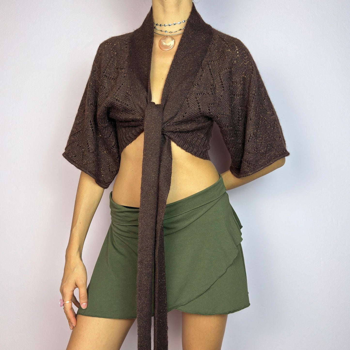 The Y2K Brown Knit Cardigan Bolero is a chic vintage 2000s piece. This cropped bolero features an open-knit design, short sleeves, and a long tie-front closure for an adjustable fit. Its warm brown tone. adult world shop