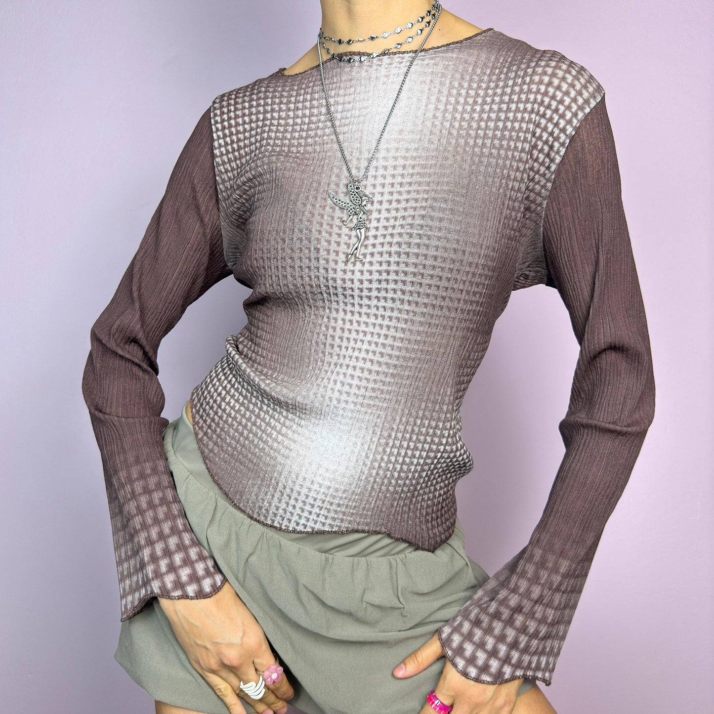 The Y2K Brown Ombre Gradient Top is a vintage 2000s semi-sheer stretchy top featuring a unique ombre gradient print that fades from deep brown to a soft beige. Designed with a subtle asymmetric cut, ribbed texture, and long sleeves, this statement piece adds a futuristic yet earthy touch to casual and streetwear outfits. Perfect for a sleek, edgy look. adult world shop