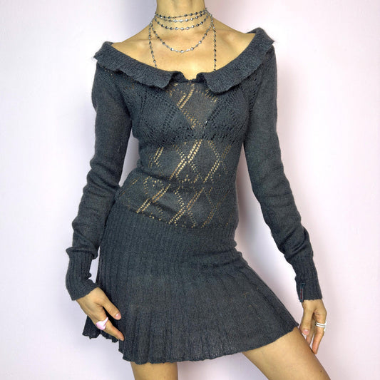 The Y2K Gray Mini Knit Dress is a vintage 2000s piece featuring a ruffled off-shoulder neckline and sheer diamond-knit pattern through the bodice. The fitted waist flows into a pleated mini skirt. Made from a soft, stretchy knit that hugs the body while remaining comfortable. Perfect for casual autumn look. adult world shop