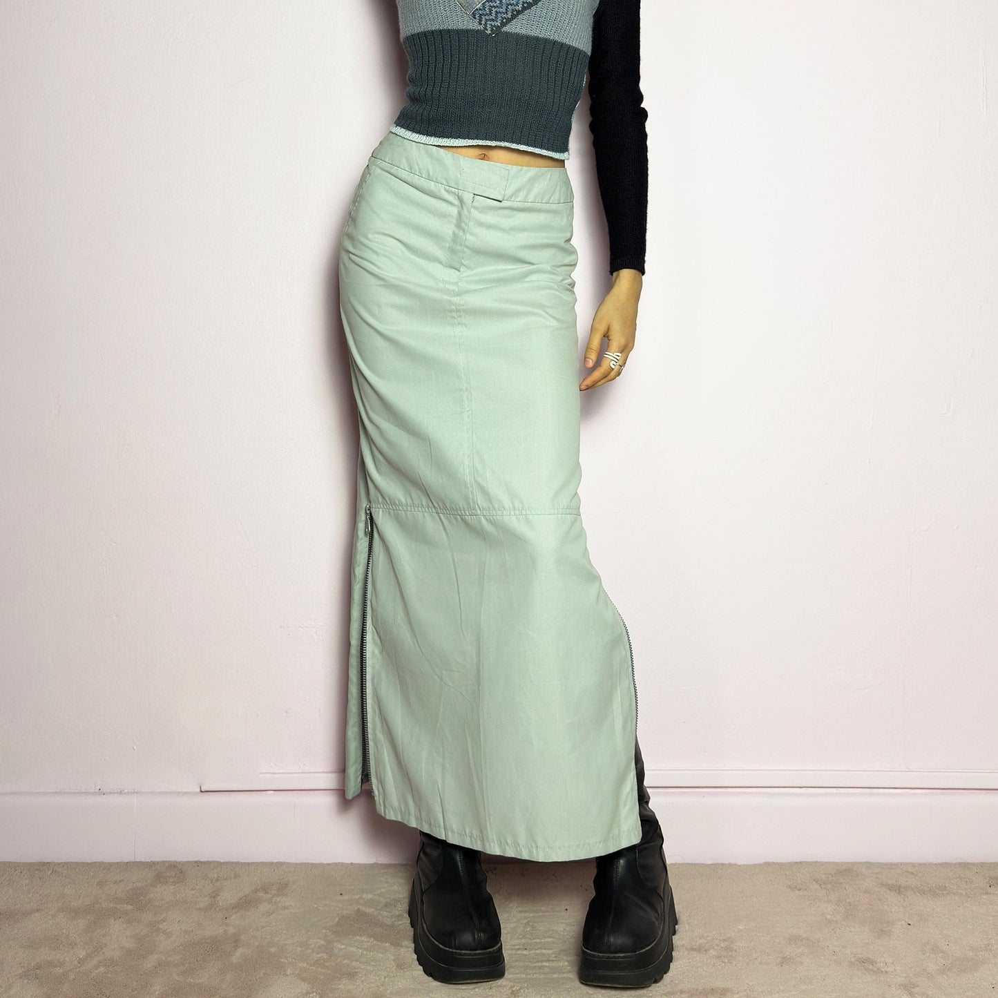 The Y2K Light Gray Maxi Skirt is a vintage 2000s piece with a sleek, futuristic aesthetic. Featuring a structured fit, and a high-rise waist, this skirt is designed for a modern, minimal look. Made from lightweight fabric, it offers a flattering silhouette with dual side zipper slits for adjustable styling. Perfect for casual, streetwear, or cyber-inspired avant-garde outfits. adult world shop
