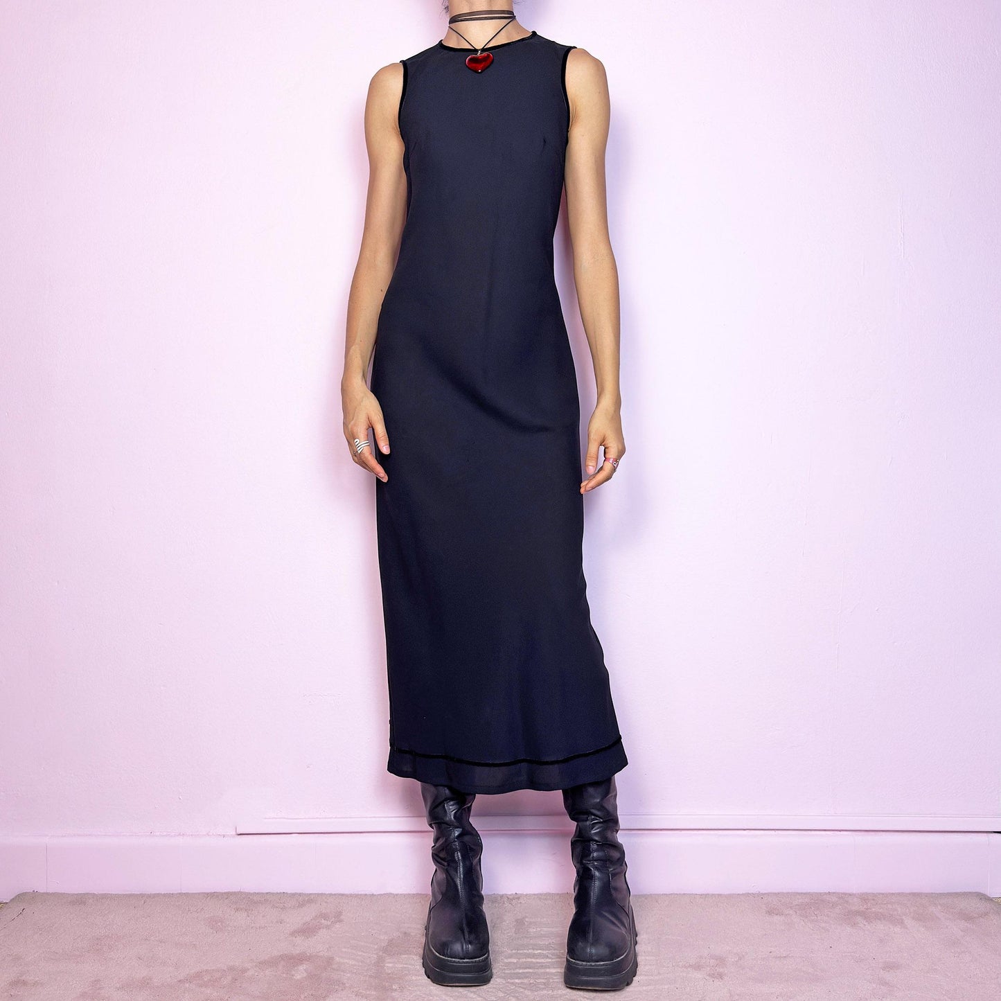 The Y2K Minimalist Black Midi Dress is a vintage 2000s sleek and timeless piece featuring a sleeveless design, and a slim, flattering fit. Crafted with lightweight, slightly sheer fabric, it drapes beautifully along the body and ends in a classic midi length. Features a back zipper closure and a back slit for ease of movement and an elegant touch. Perfect for minimalist, officecore, or elegant 90s-inspired looks. Effortlessly versatile for both casual layering and dressier night-out outfits.